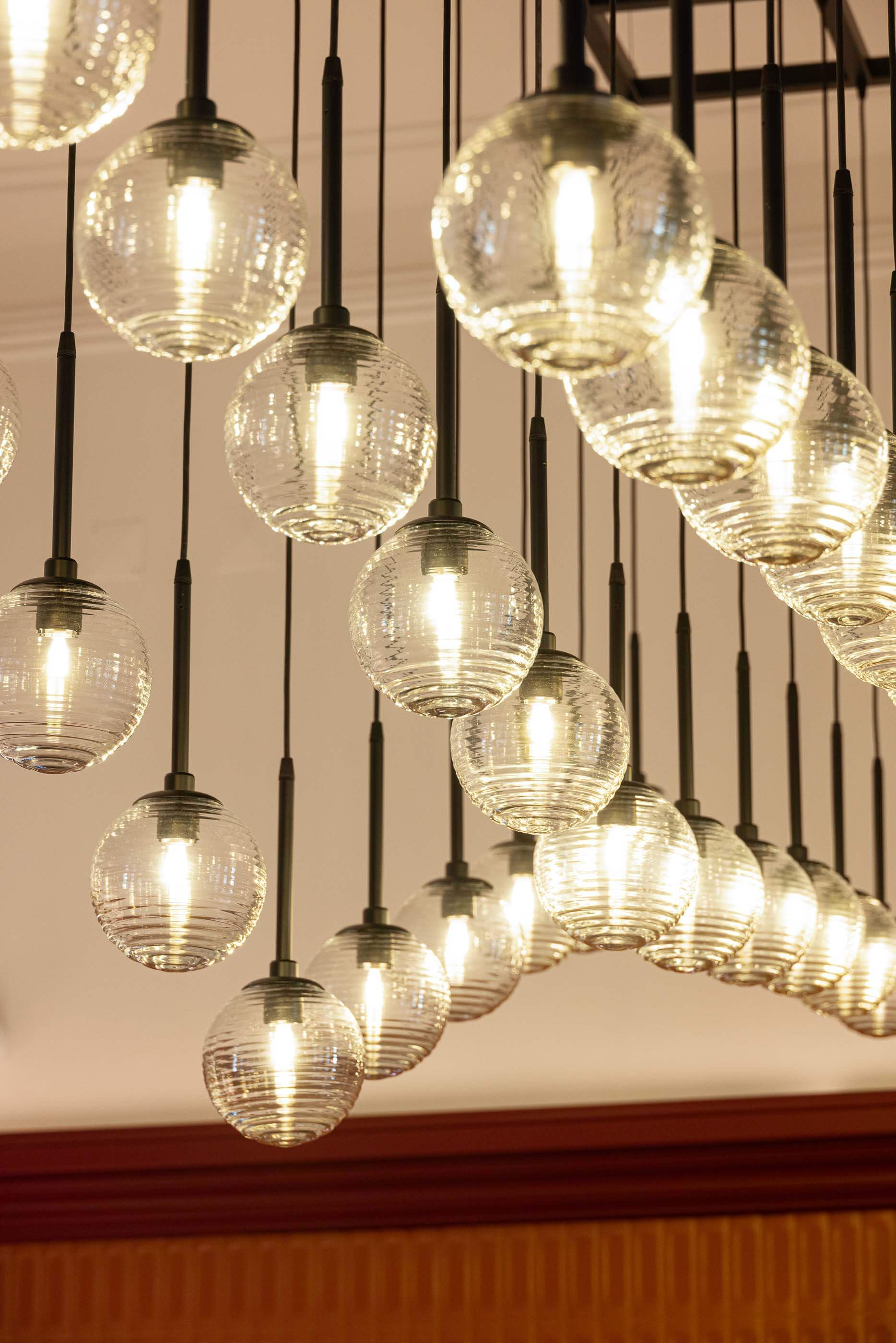 Restaurante: Detalhe da iluminação suspensa sobre o bar, com globos de vidro texturado. — Restaurante Concerto arquitetura MiMool Arquitectura & Interiores em vila do conde