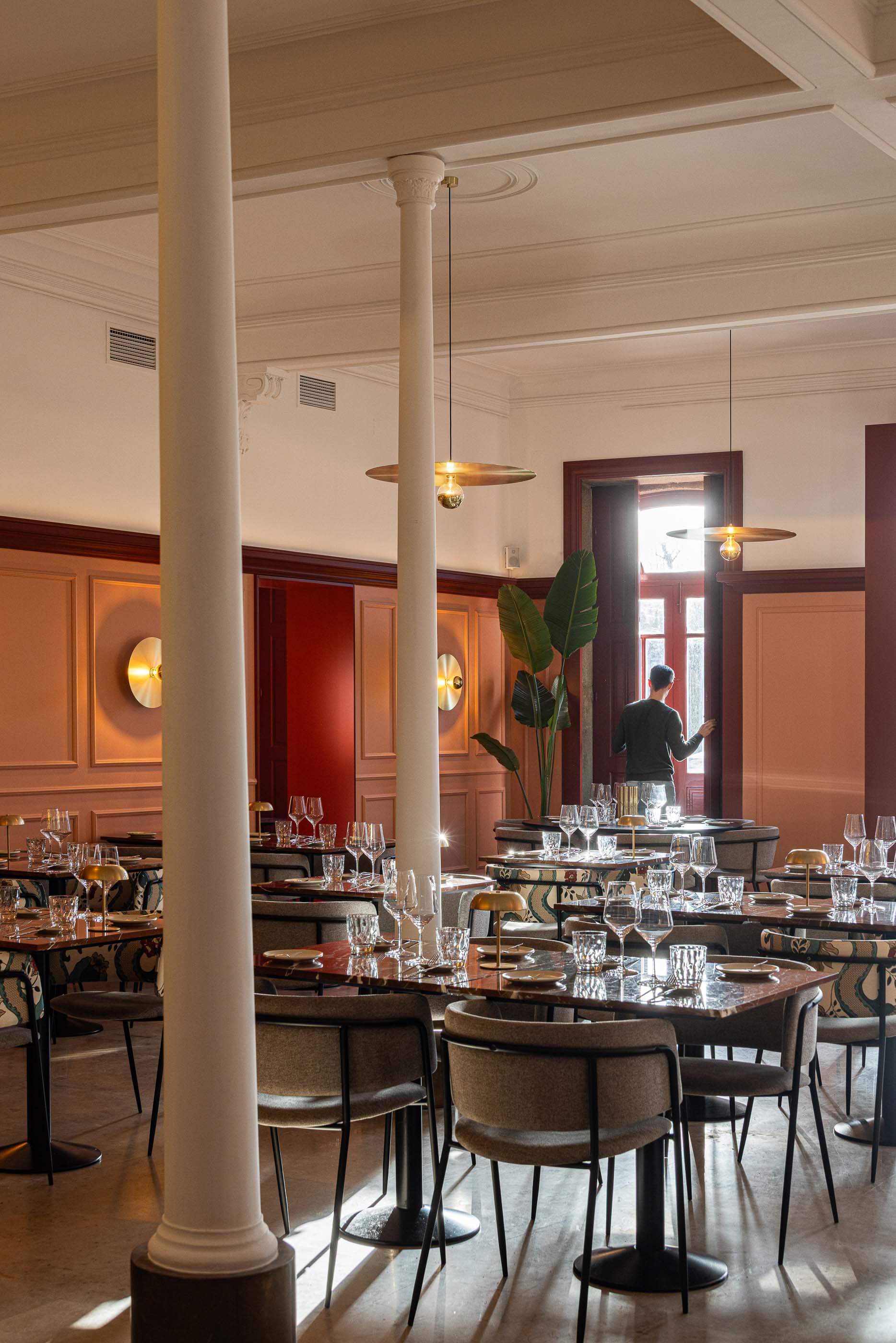 Restaurante: Salão com mesas de mármore, cadeiras variadas, colunas clássicas e iluminação dourada. — Restaurante Concerto arquitetura MiMool Arquitectura & Interiores em vila do conde