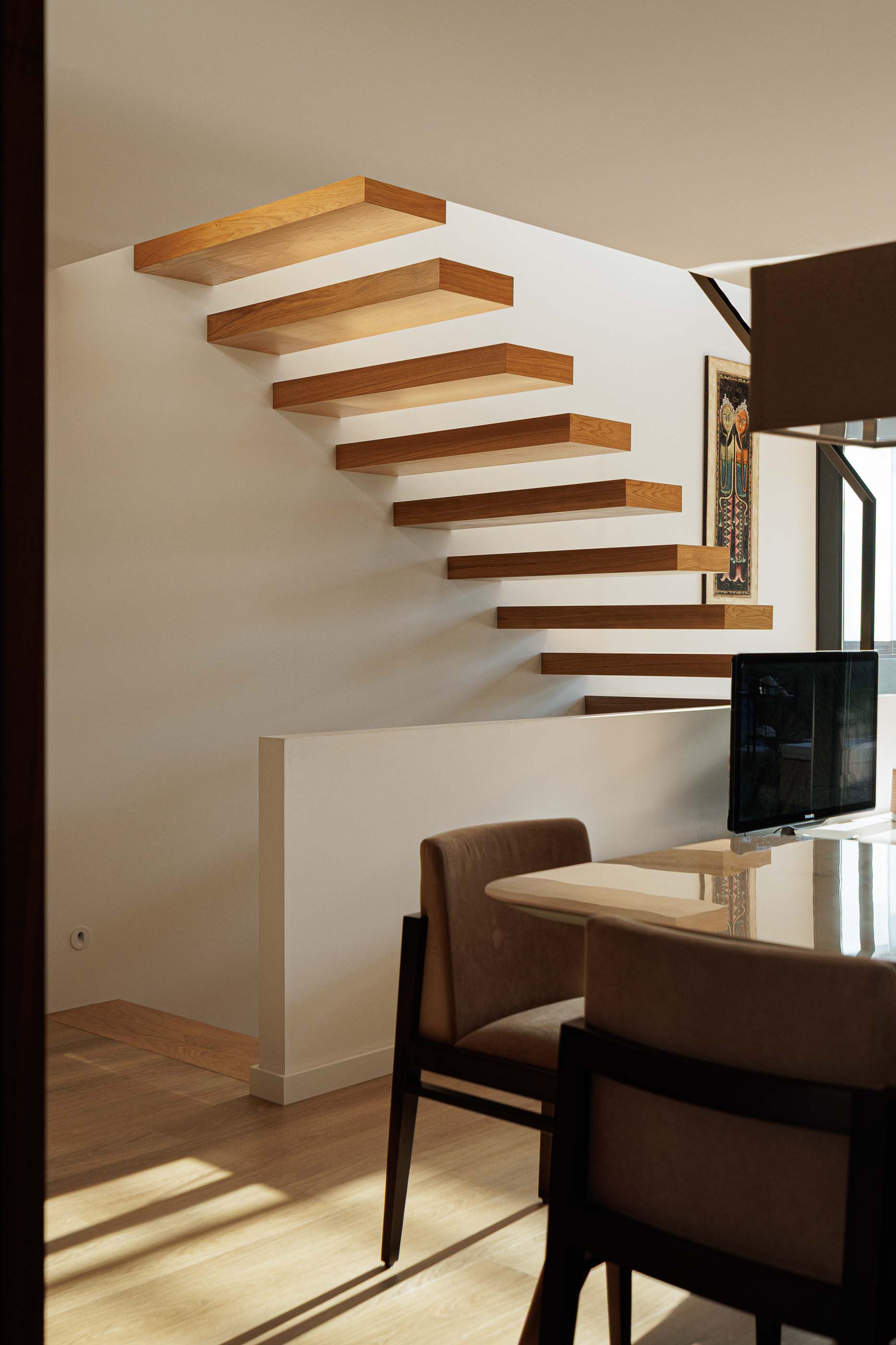 Escadas: Detalhe das escadas flutuantes em madeira com iluminação zenital. Design moderno. — Casa Pi arquitetura ArquitectosRT em Porto
