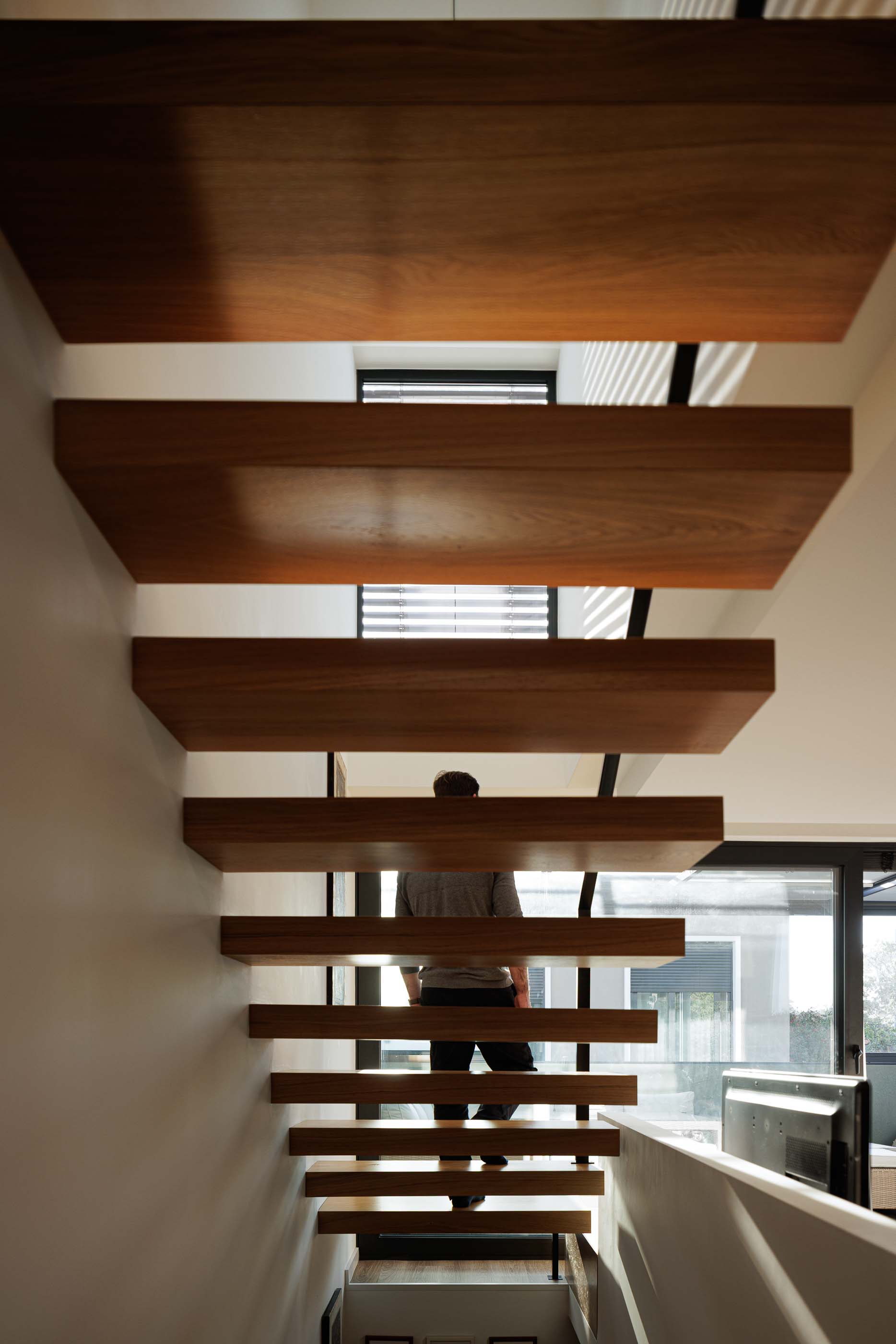 Escadas: Vista das escadas em madeira com candeeiros suspensos e marquise ao fundo. — Casa Pi arquitetura ArquitectosRT em Porto