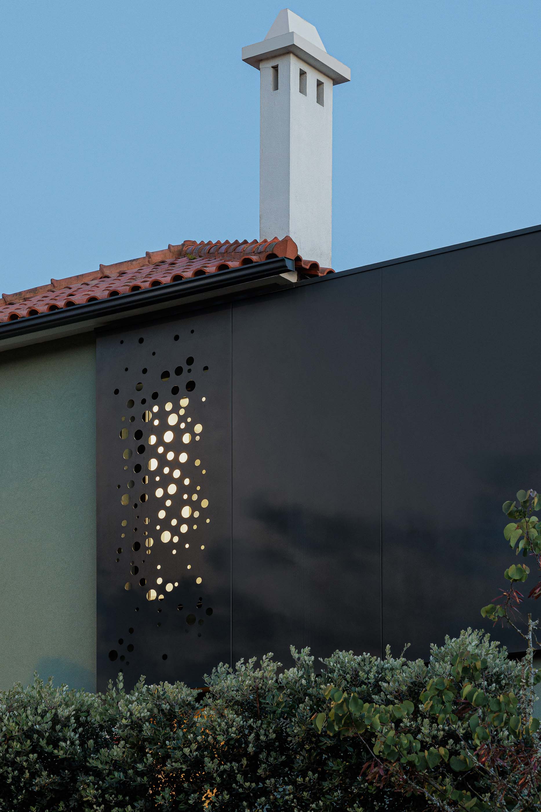 Exterior: Vista noturna da casa com anexo preto, marquise envidraçada e vegetação. — Casa Pi arquitetura ArquitectosRT em Porto