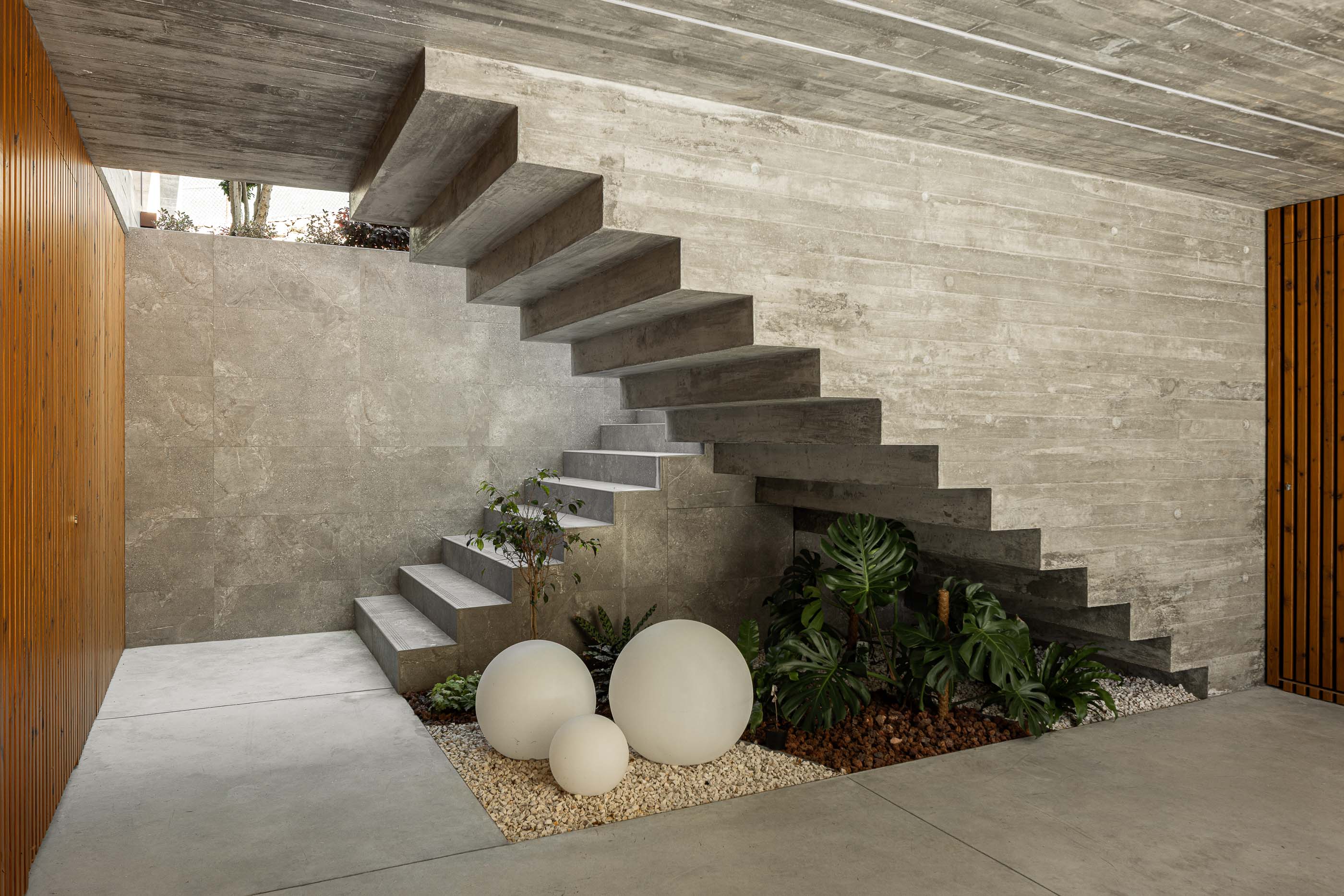 Escadas: Escadas em betão aparente, com jardim interior e iluminação indireta. — Habitação CL arquitetura Artequitectos em Guimarães