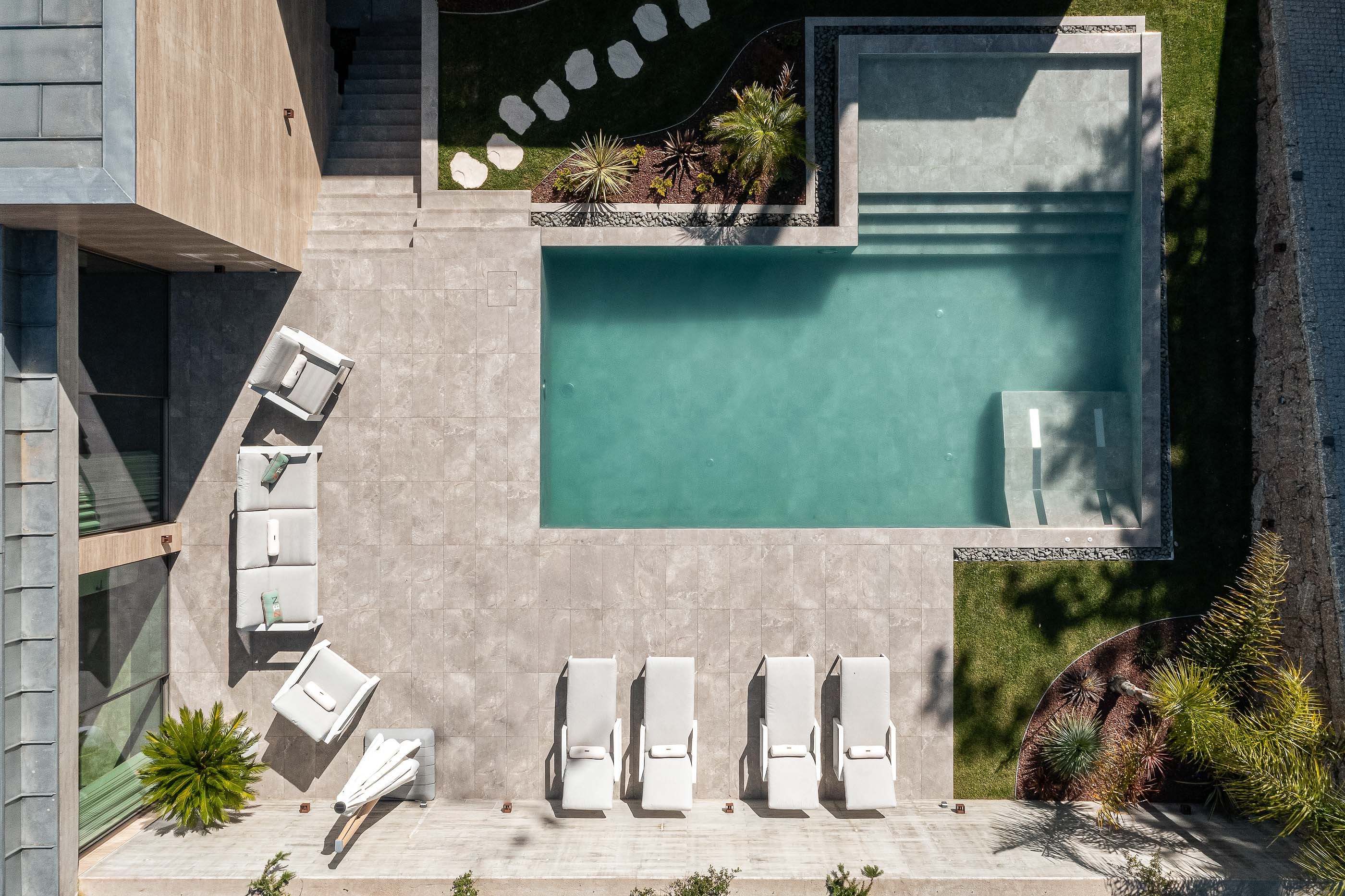 Exterior: Vista aérea da piscina, com zona de estar e jardim. — Habitação CL arquitetura Artequitectos em Guimarães