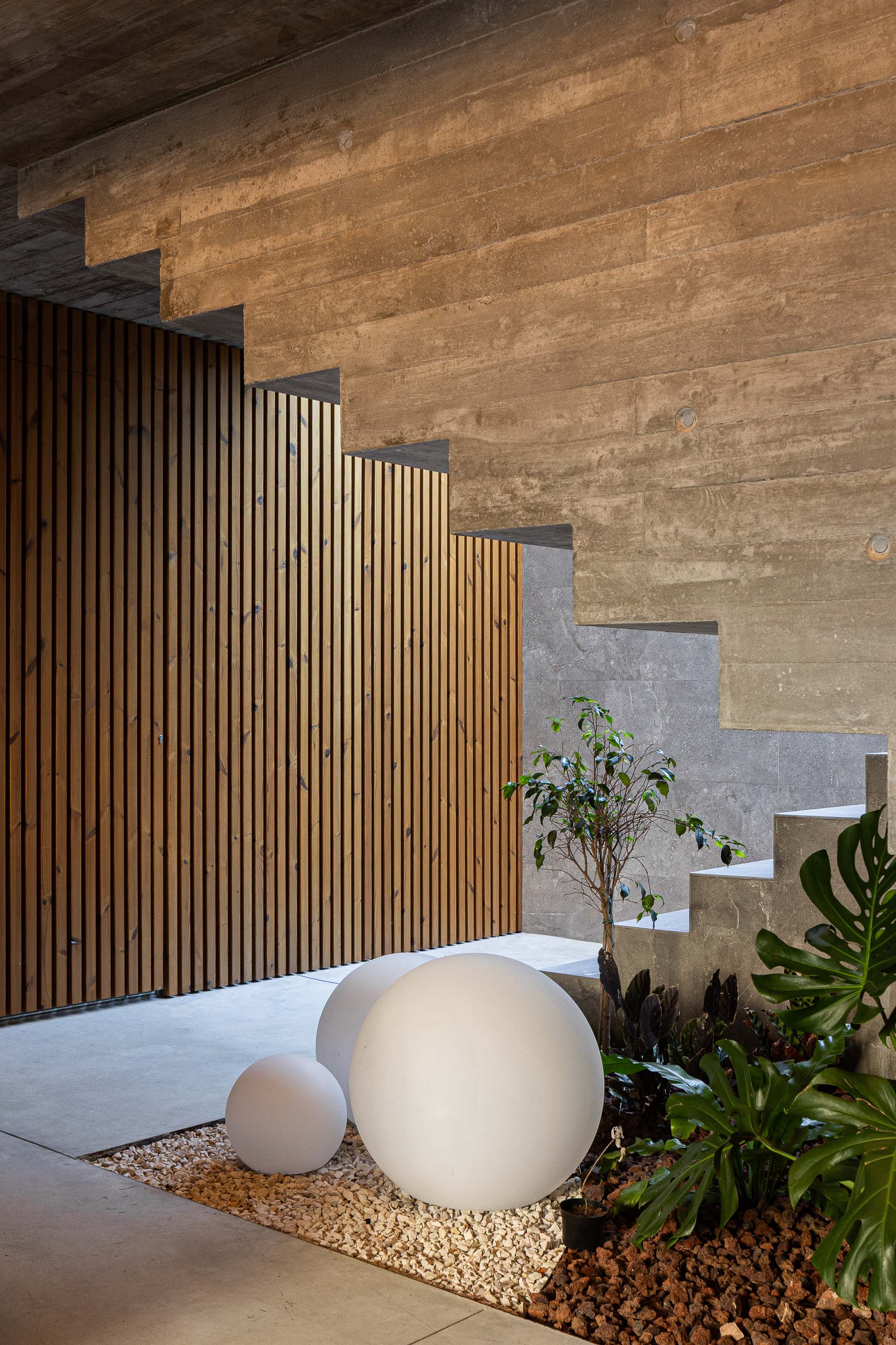 Garagem: Detalhe da garagem com escadas, jardim interior e iluminação. — Habitação CL arquitetura Artequitectos em Guimarães