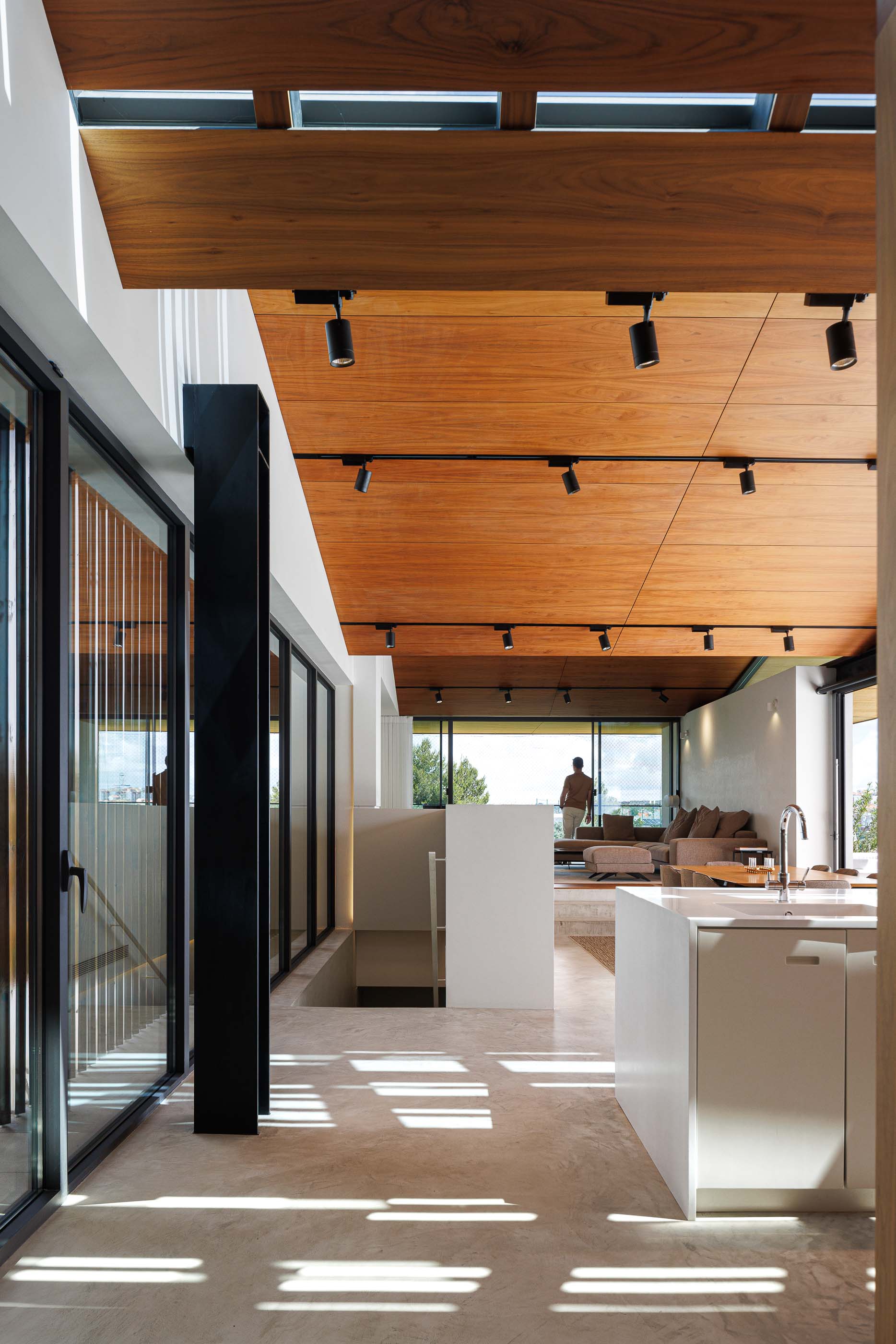 Sala de estar: Interior com teto em madeira, iluminação direcionada, janelas amplas e mobiliário moderno. — Casa dos Alcoutins arquitetura Paulo Martins Arquitectura e Design em Lisboa