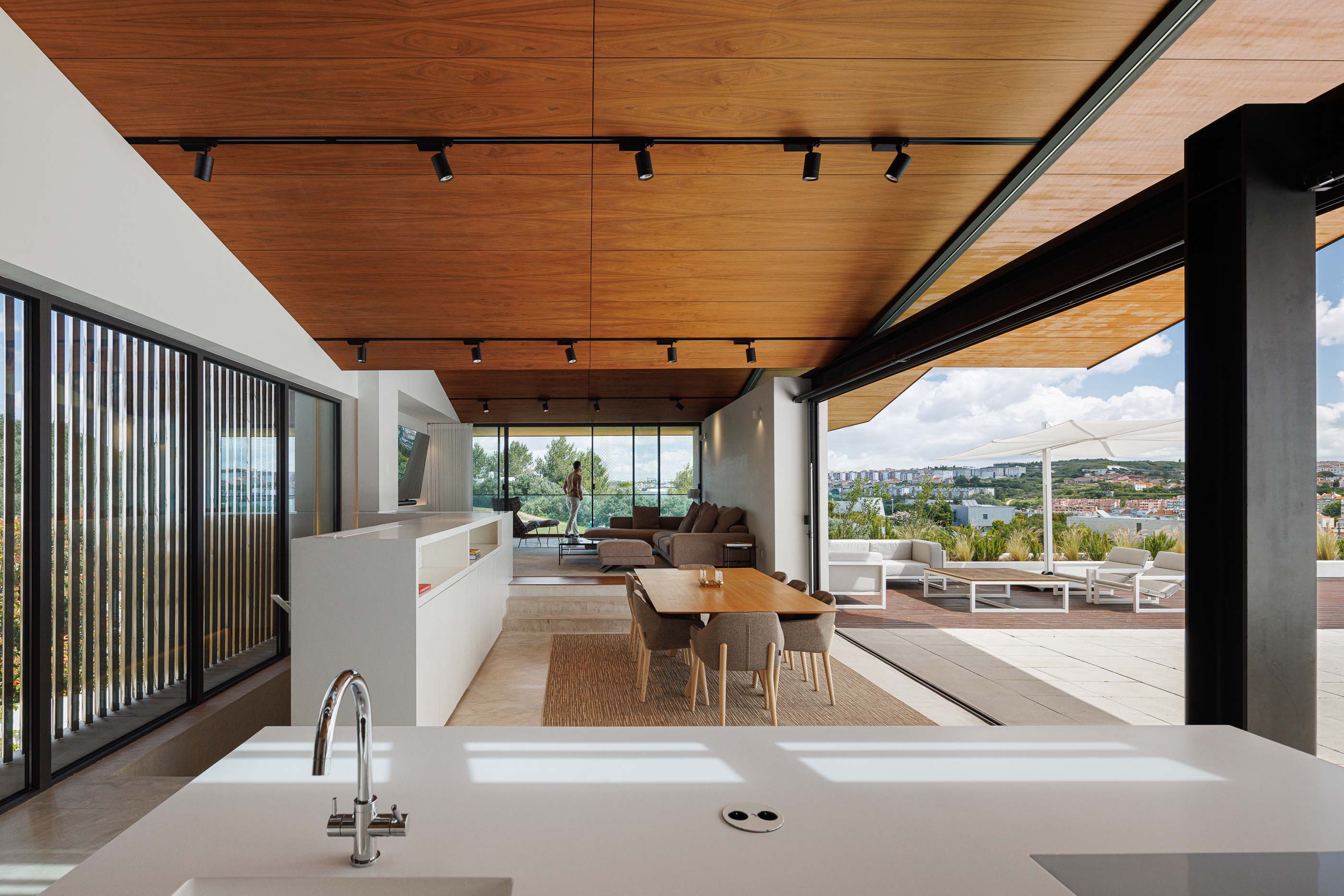 Sala de estar: Espaço amplo com cozinha integrada, zona de refeições, sala de estar e acesso ao terraço. — Casa dos Alcoutins arquitetura Paulo Martins Arquitectura e Design em Lisboa