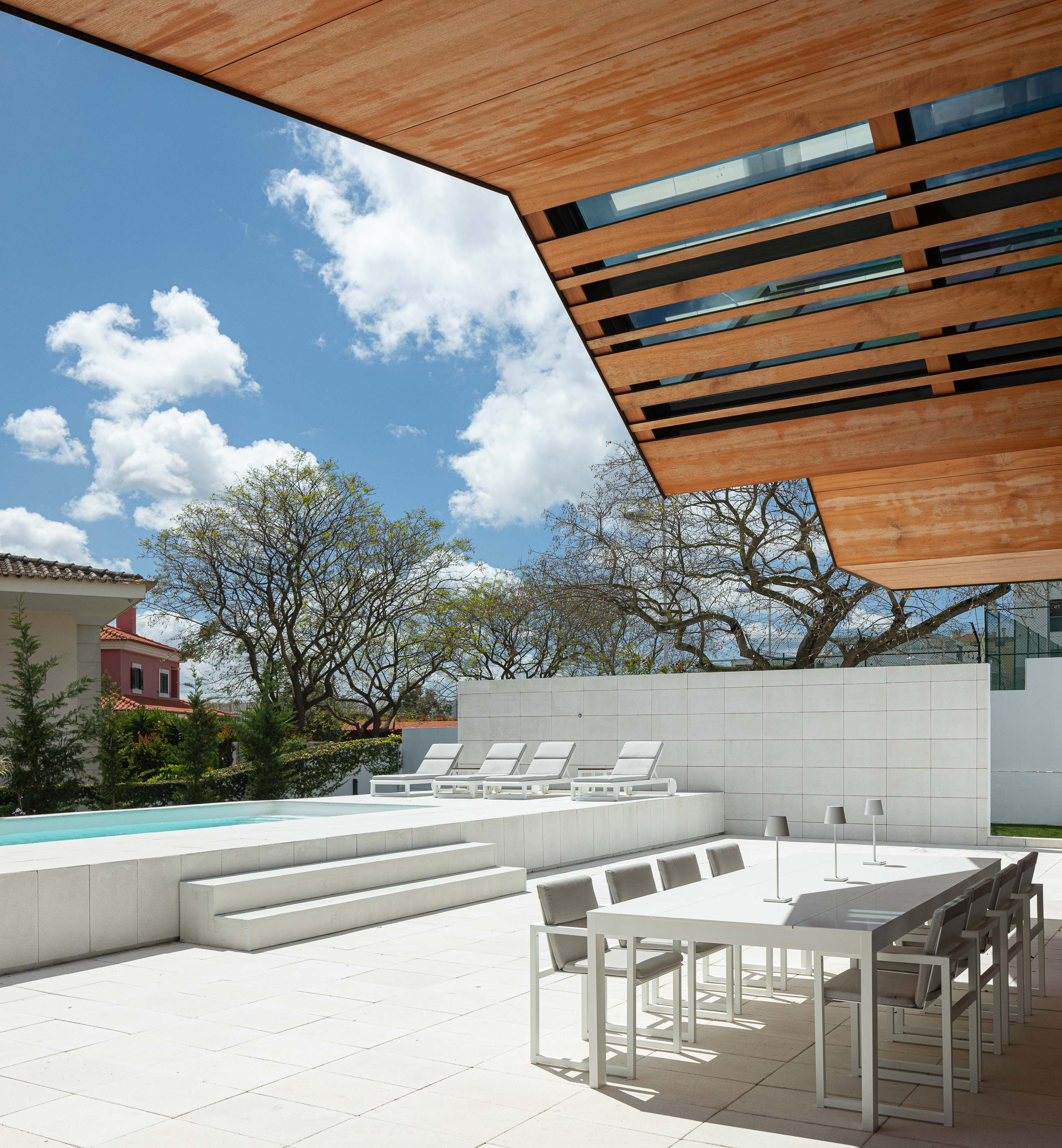 Terraço: Vista do terraço com piscina, zona de refeições e teto em madeira. — Casa dos Alcoutins arquitetura Paulo Martins Arquitectura e Design em Lisboa
