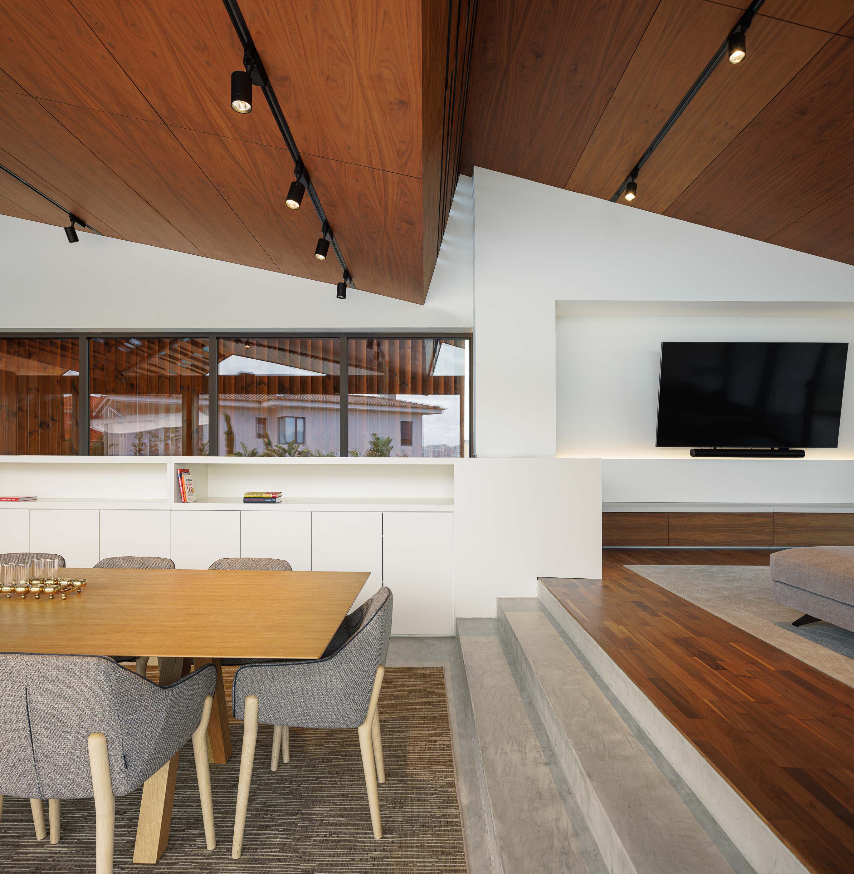 Sala de estar: Interior com teto em madeira, iluminação direcionada, sofá confortável e acesso ao terraço. — Casa dos Alcoutins arquitetura Paulo Martins Arquitectura e Design em Lisboa