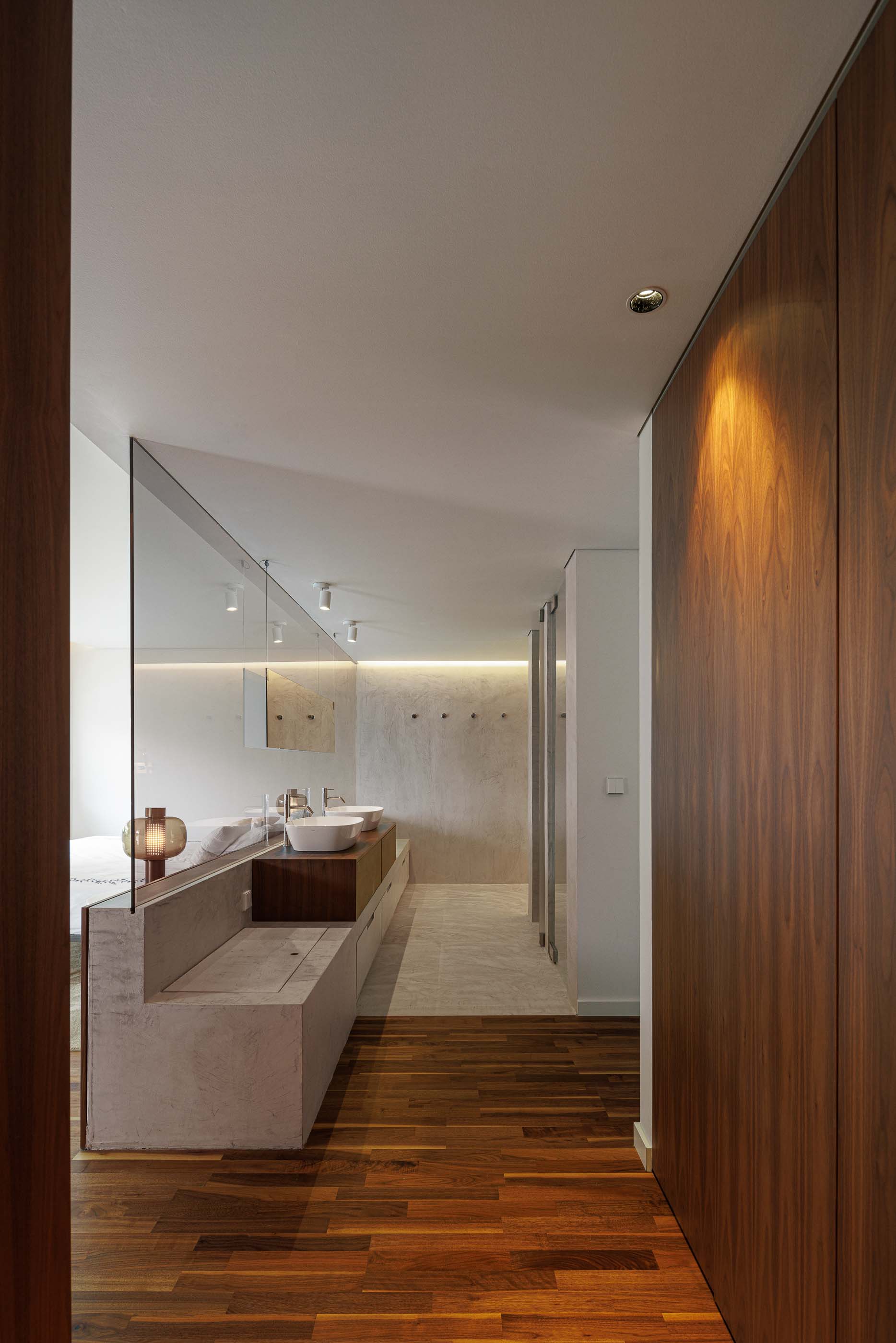 Quarto: Detalhe do quarto com candeeiro de mesa, roupeiro em madeira e pavimento em madeira. — Casa dos Alcoutins arquitetura Paulo Martins Arquitectura e Design em Lisboa