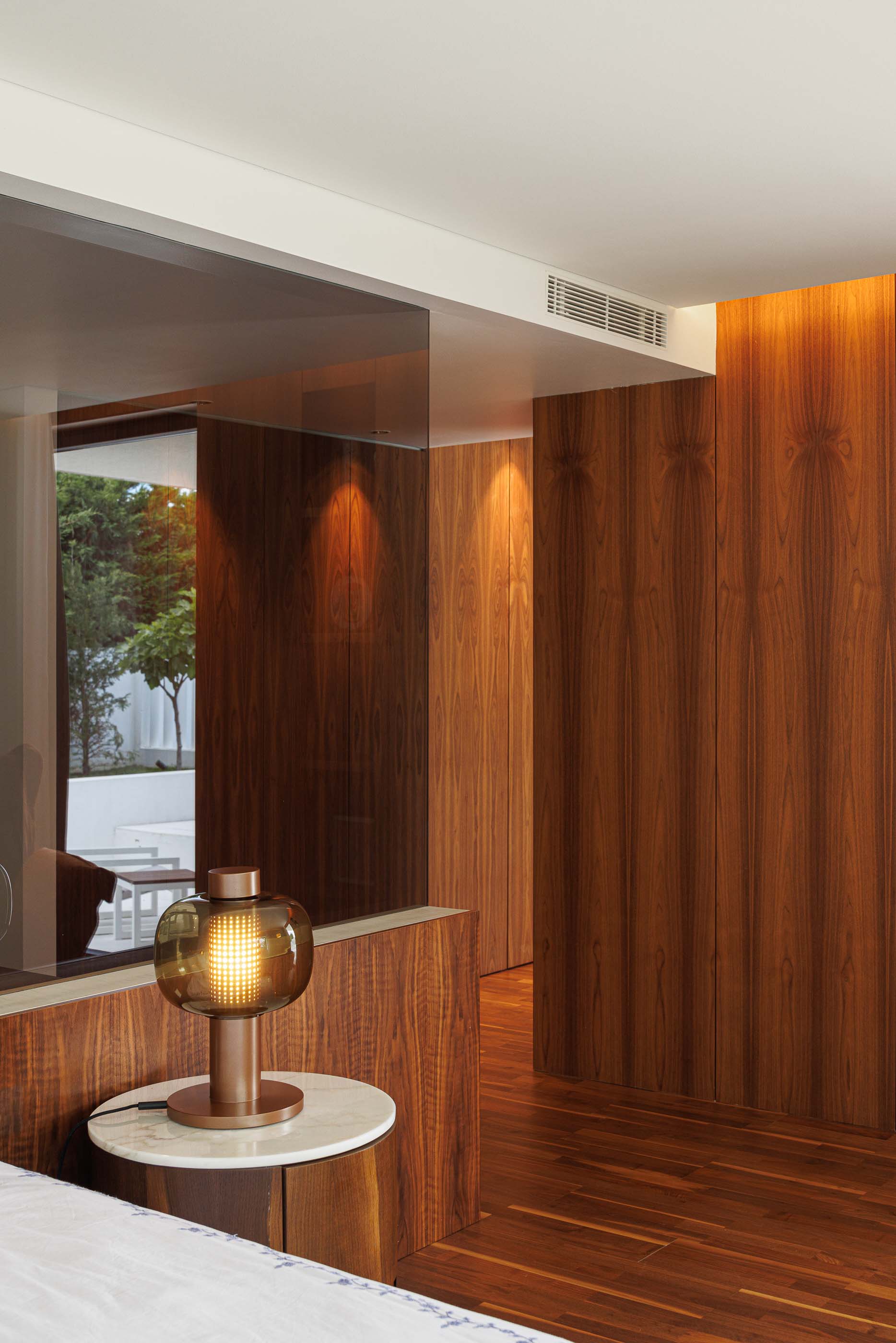 Escritório: Espaço de trabalho com secretária, cadeira ergonómica, roupeiro em madeira e acesso ao quarto de banho. — Casa dos Alcoutins arquitetura Paulo Martins Arquitectura e Design em Lisboa