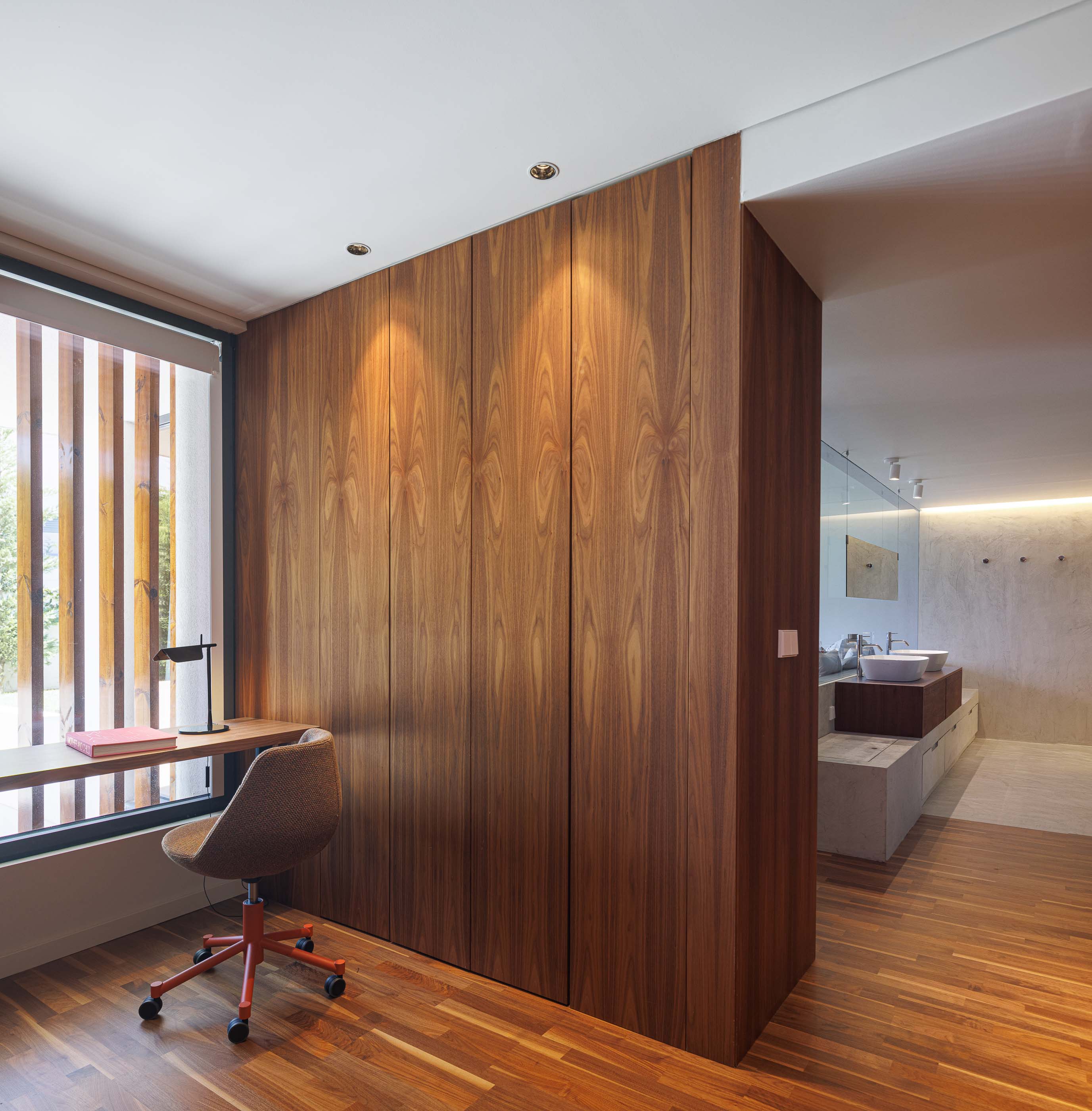 Escritório: Detalhe da secretária com candeeiro, cadeira ergonómica e pavimento em madeira. — Casa dos Alcoutins arquitetura Paulo Martins Arquitectura e Design em Lisboa