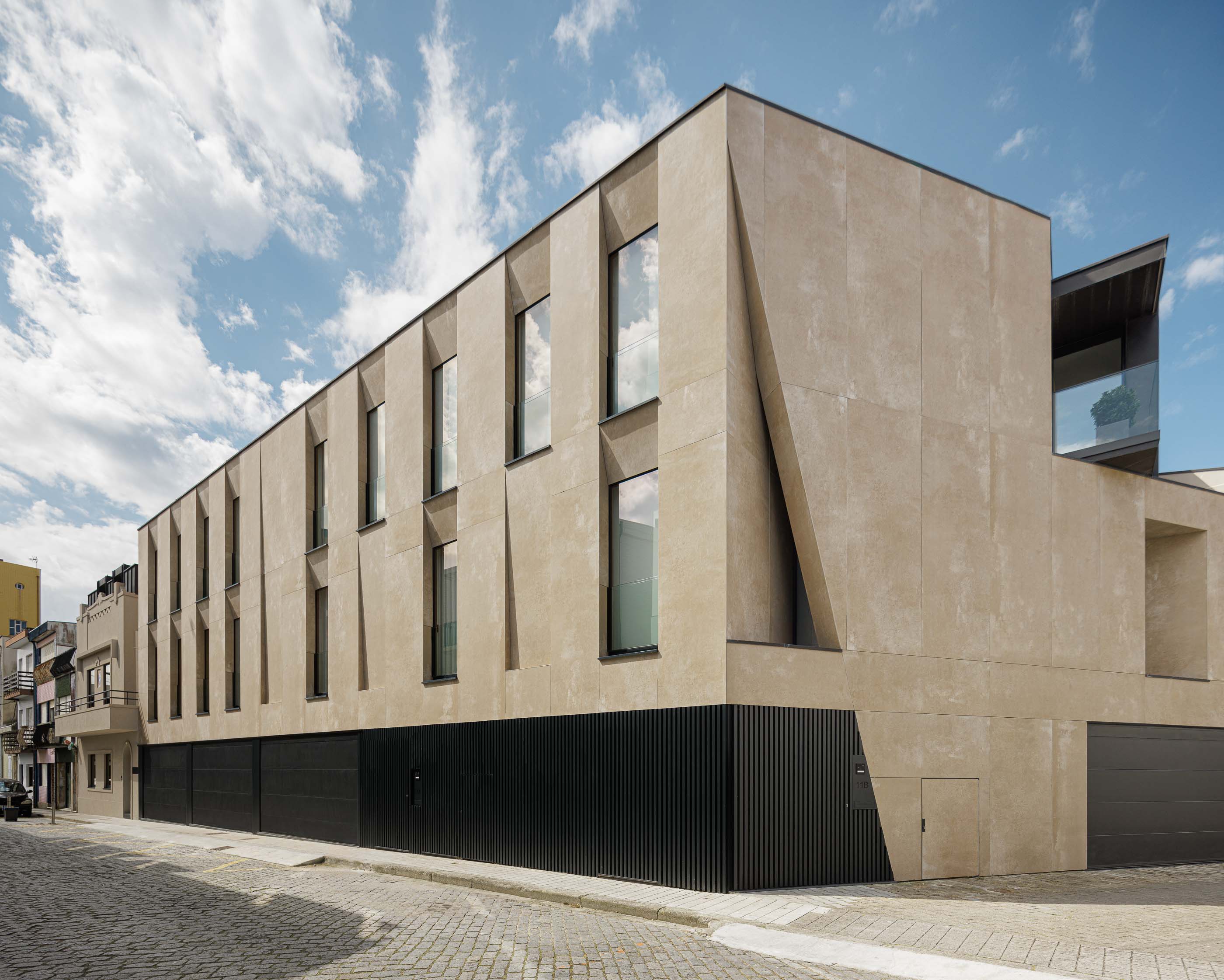 Fachada: Edifício com design moderno, fachada em tons terra, janelas e detalhes geométricos. — Reabilitação Poveira - Edifício FS11 arquitetura Urbanpolis em Póvoa de Varzim