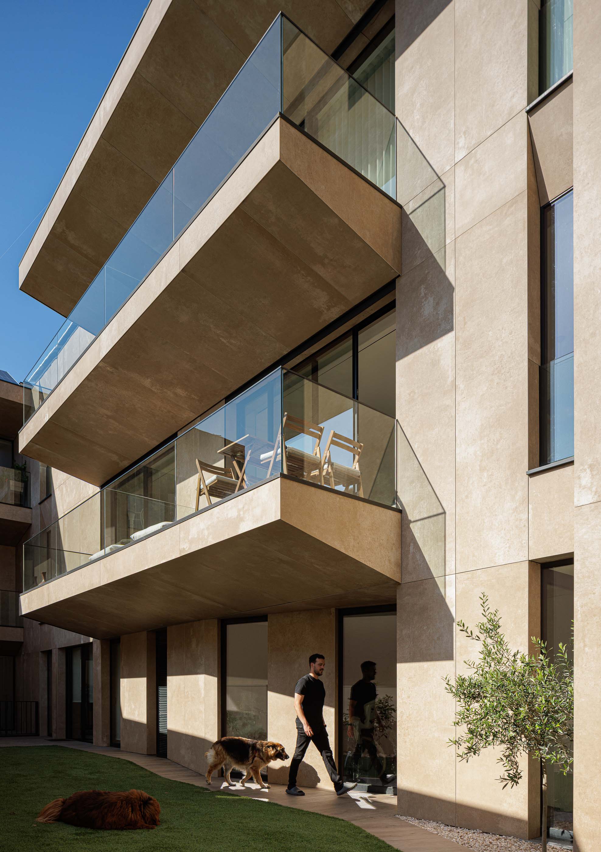 Exterior: Edifício com varandas envidraçadas, jardim relvado e pavimento em calçada. — Reabilitação Poveira - Edifício FS11 arquitetura Urbanpolis em Póvoa de Varzim