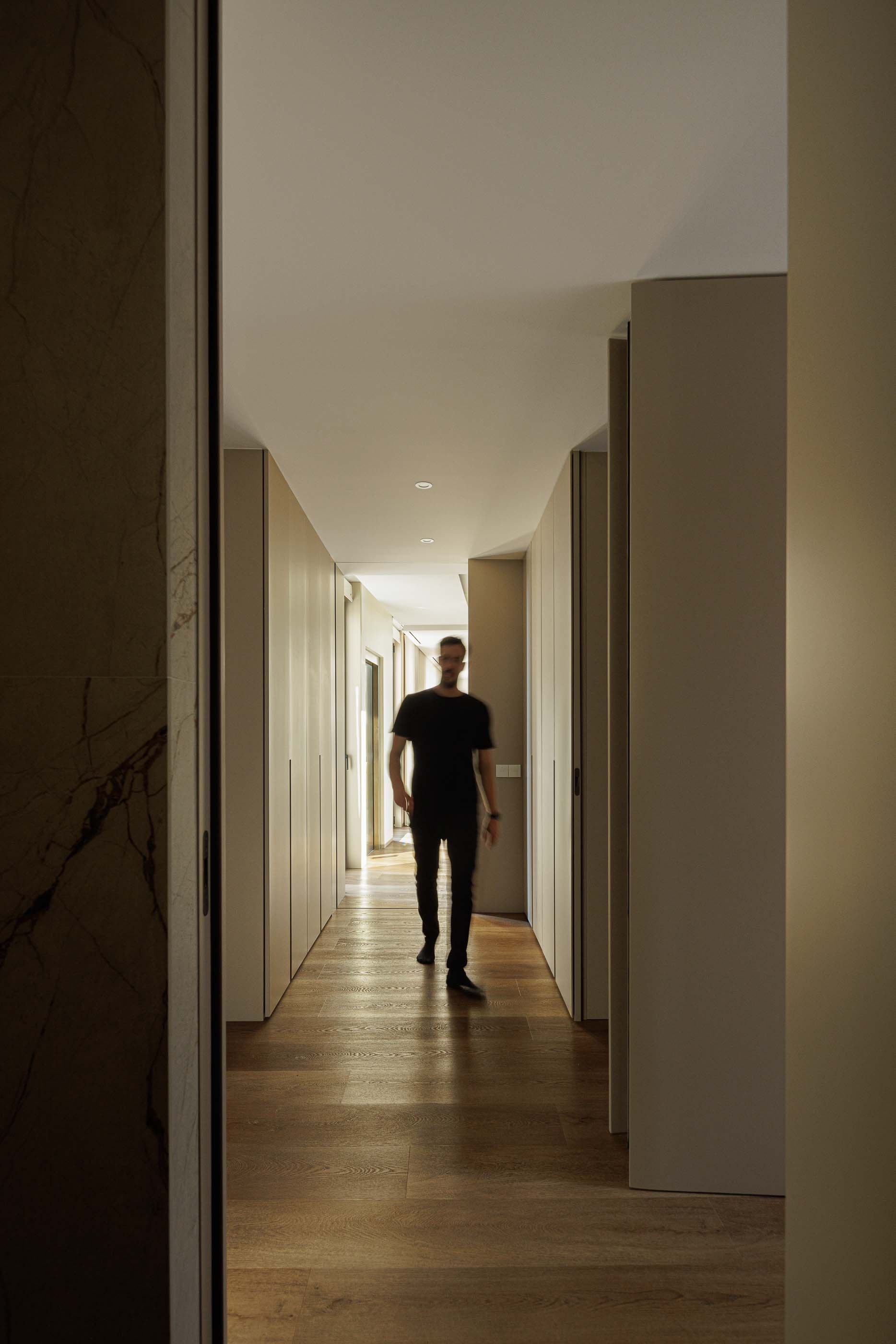 Corredor: Corredor com armários embutidos, pavimento em madeira e iluminação embutida. — Reabilitação Poveira - Edifício FS11 arquitetura Urbanpolis em Póvoa de Varzim