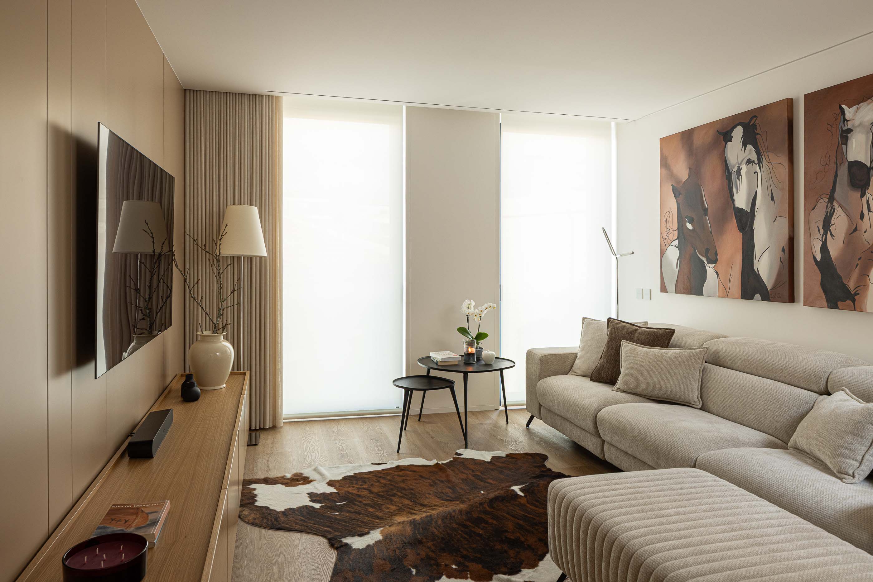 Sala de estar: Sala de estar com sofá claro, tapete de pele e móveis em madeira. — Reabilitação Poveira - Edifício FS11 arquitetura Urbanpolis em Póvoa de Varzim