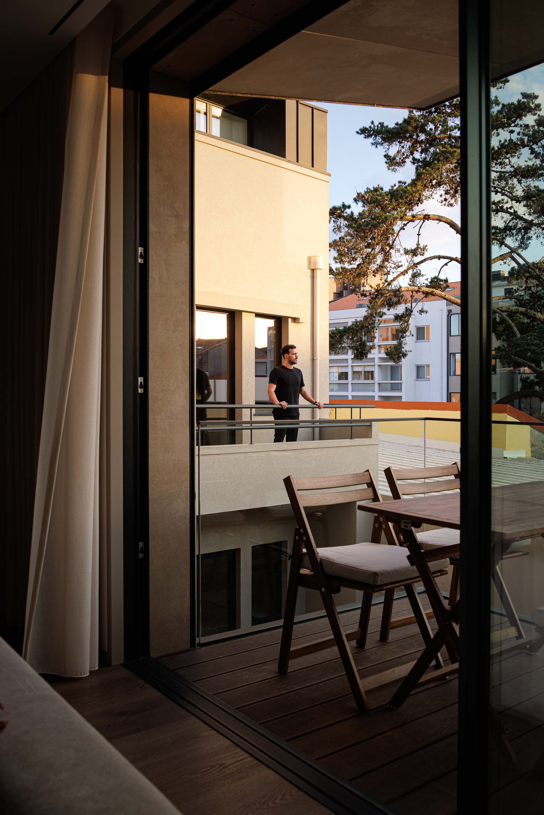 Exterior: Edifício com varandas envidraçadas, jardim relvado e iluminação exterior. — Reabilitação Poveira - Edifício FS11 arquitetura Urbanpolis em Póvoa de Varzim