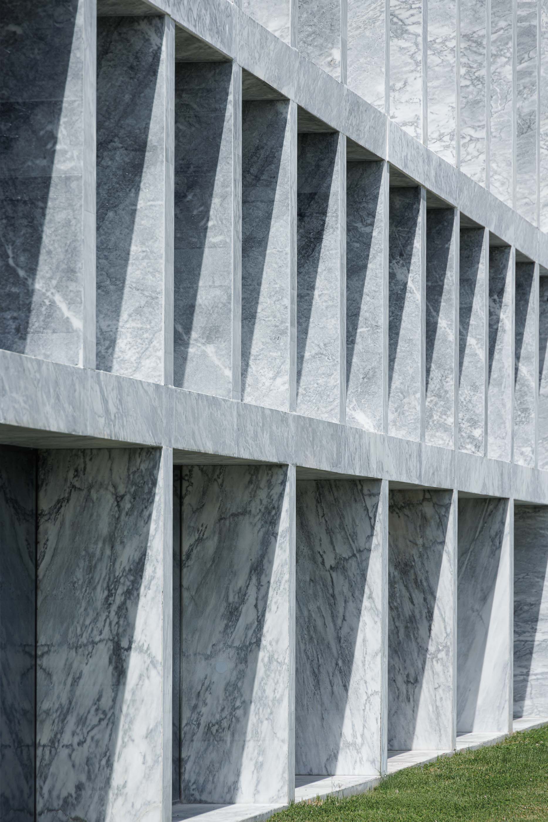 Edifício: Detalhe da fachada em mármore com janelas profundas, criando um jogo de luz e sombra. — Metyis Digital Campus arquitetura UNUM - Oficina de Arquitetura em Gondomar