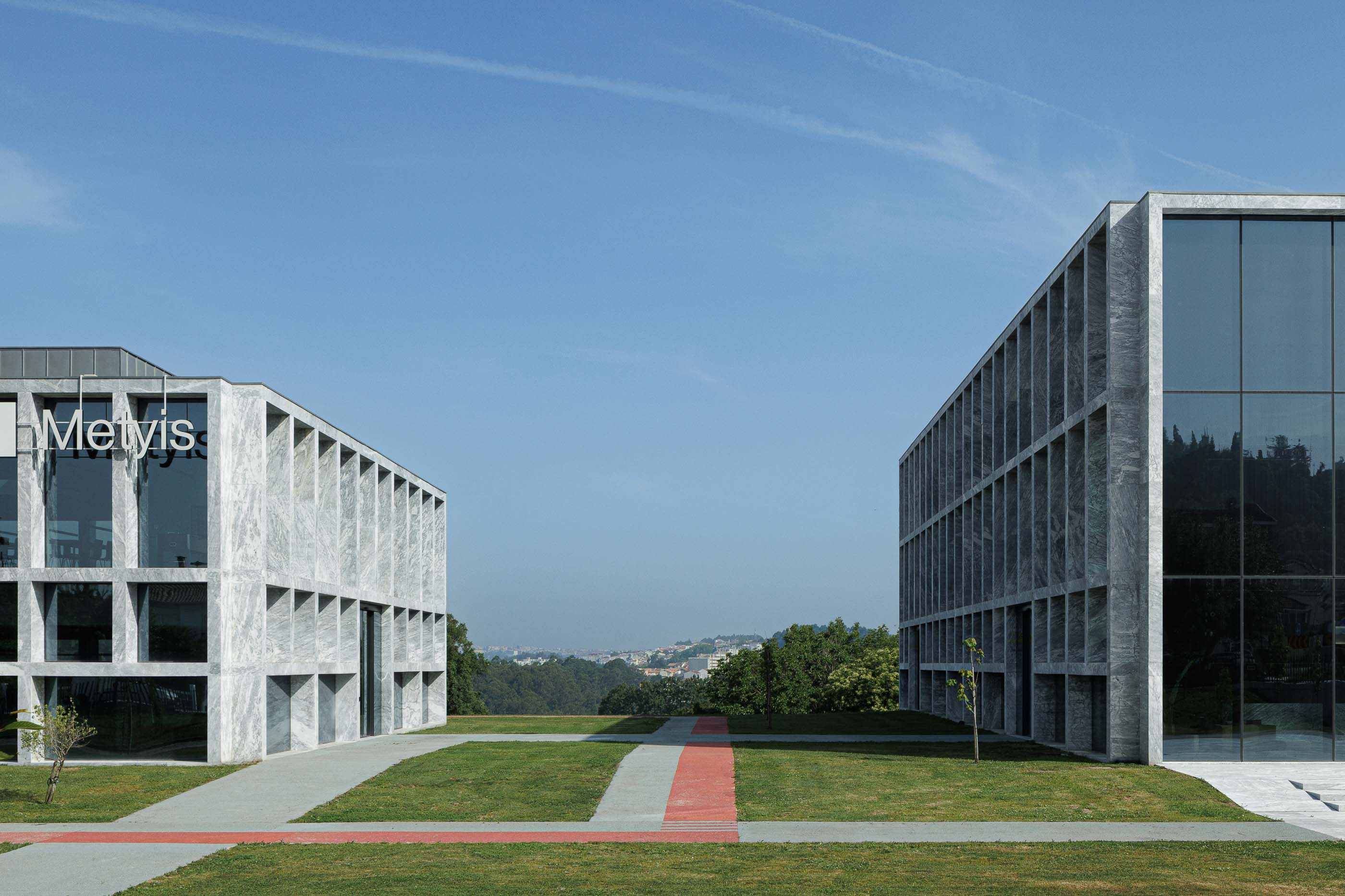 Exterior: Vista entre dois edifícios do Metyis Digital Campus, com relvado e passagens pedonais. — Metyis Digital Campus arquitetura UNUM - Oficina de Arquitetura em Gondomar