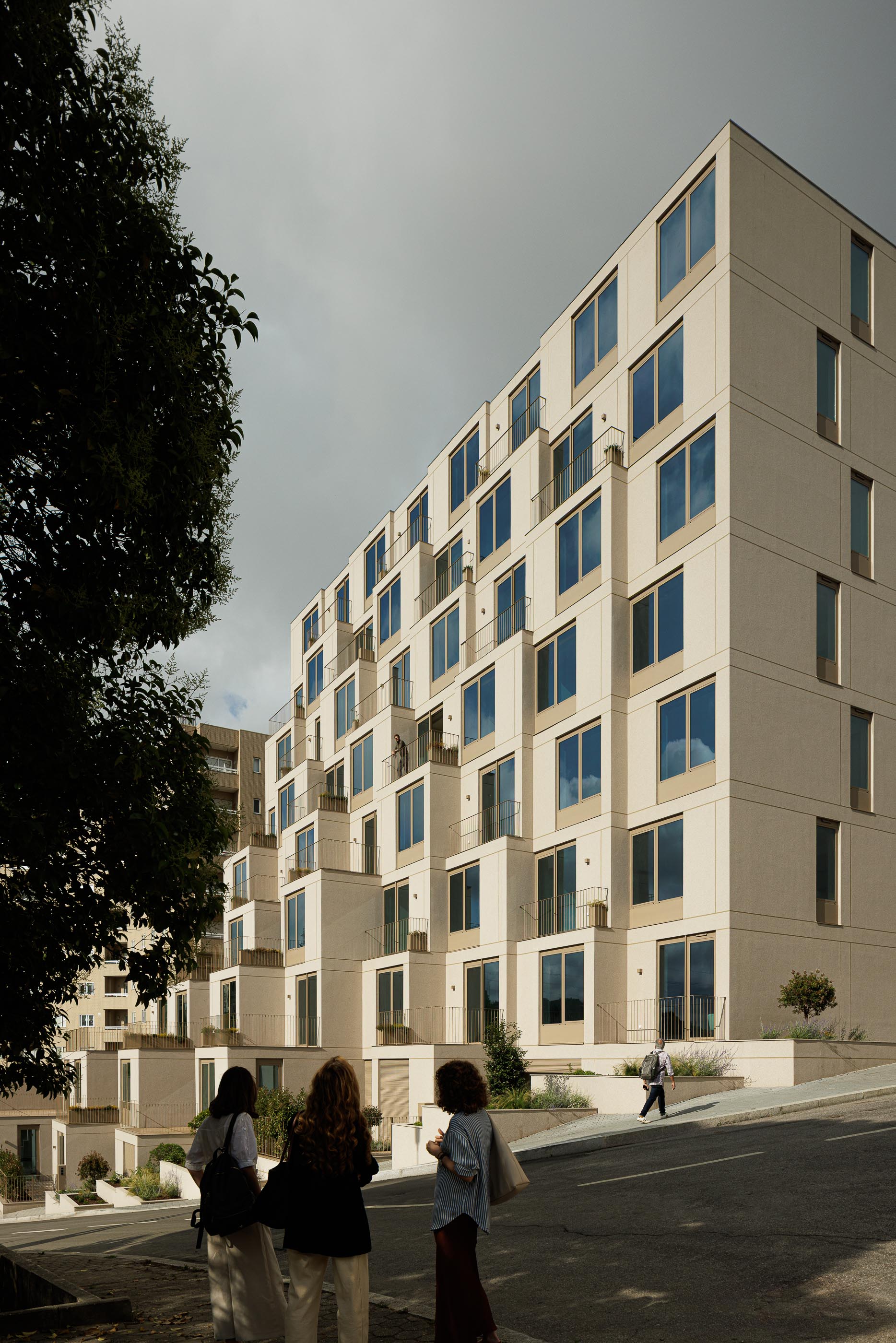 Fachada: Edifício de apartamentos com varandas escalonadas, fachada bege texturada e caixilharias castanhas. — Macau Valley arquitetura hori-zonte em Vila Nova de Gaia