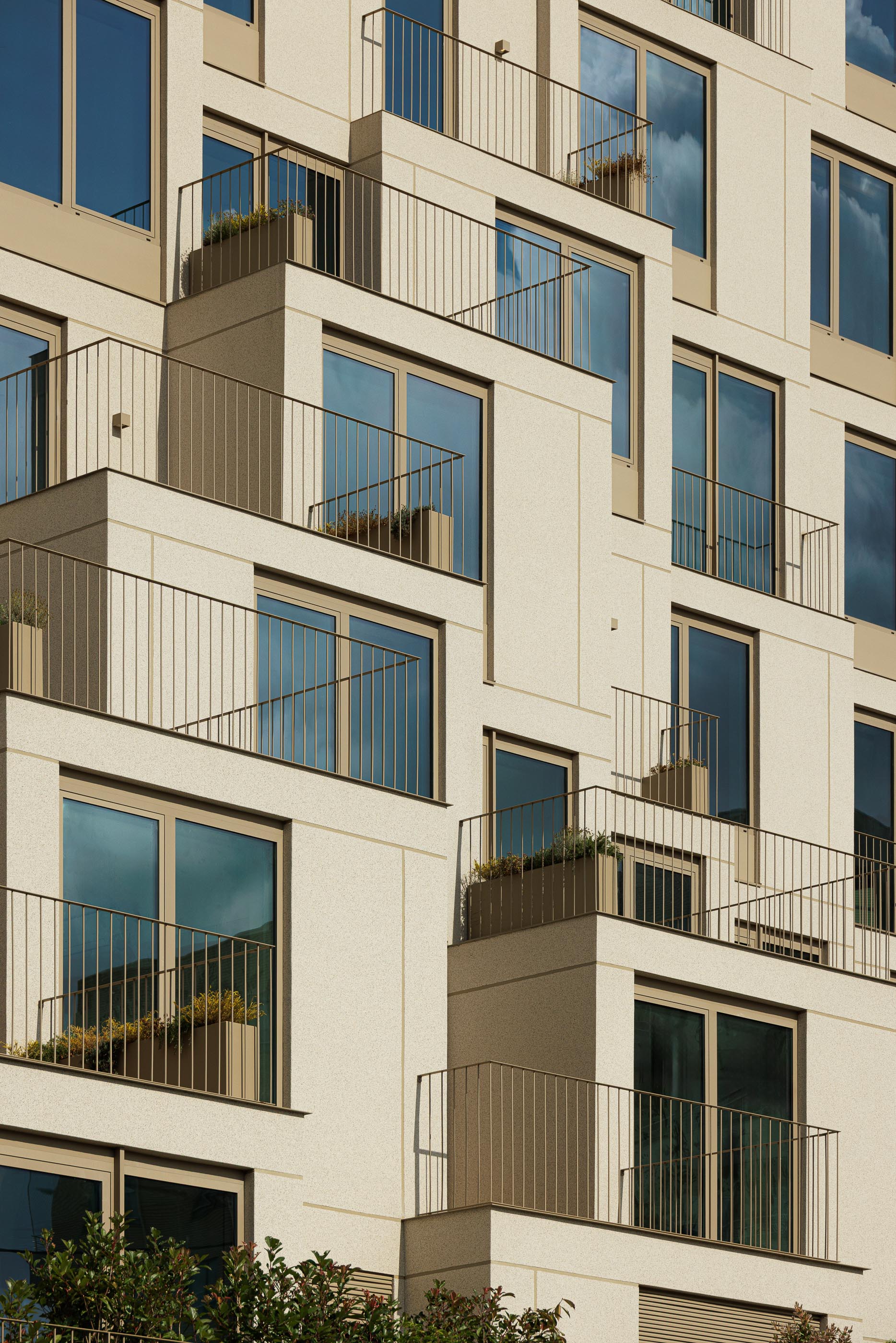 Fachada: Detalhe das varandas escalonadas com gradeamento metálico e floreiras embutidas. — Macau Valley arquitetura hori-zonte em Vila Nova de Gaia