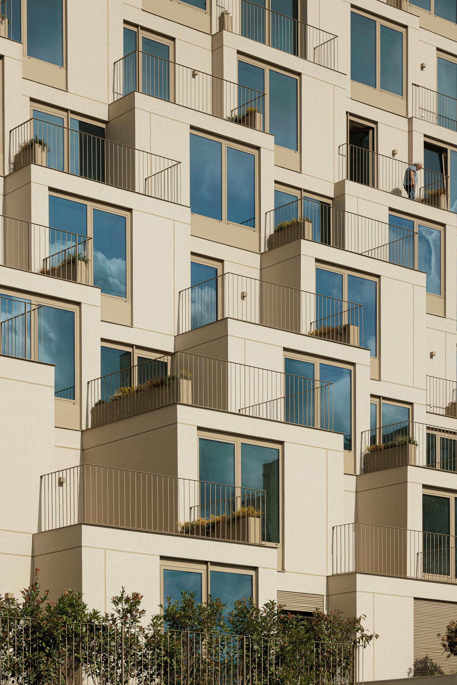 Fachada: Detalhe das varandas escalonadas com gradeamento metálico e floreiras embutidas. — Macau Valley arquitetura hori-zonte em Vila Nova de Gaia