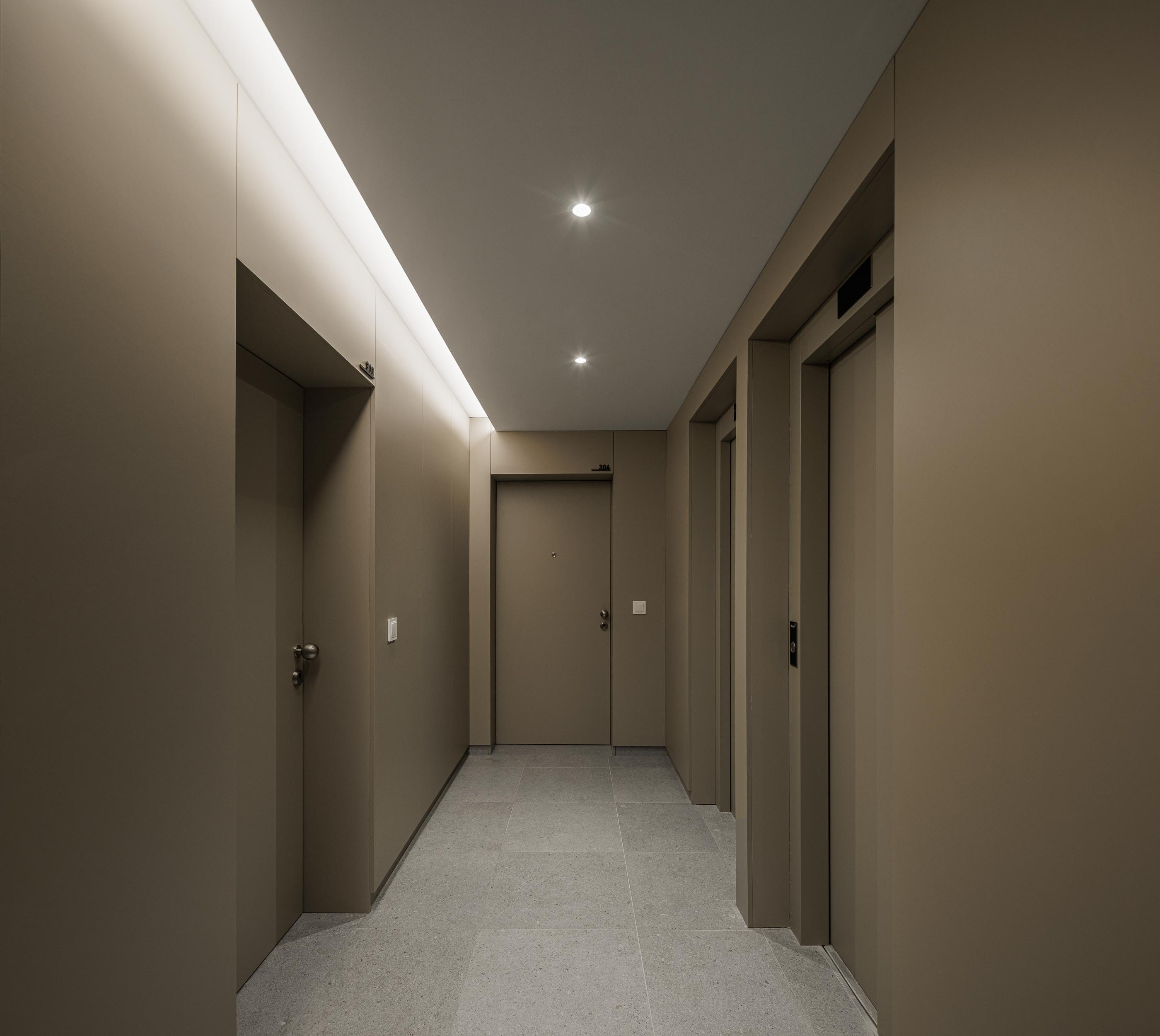 Corredor: Corredor de acesso aos apartamentos com pavimento cerâmico e iluminação embutida. — Macau Valley arquitetura hori-zonte em Vila Nova de Gaia