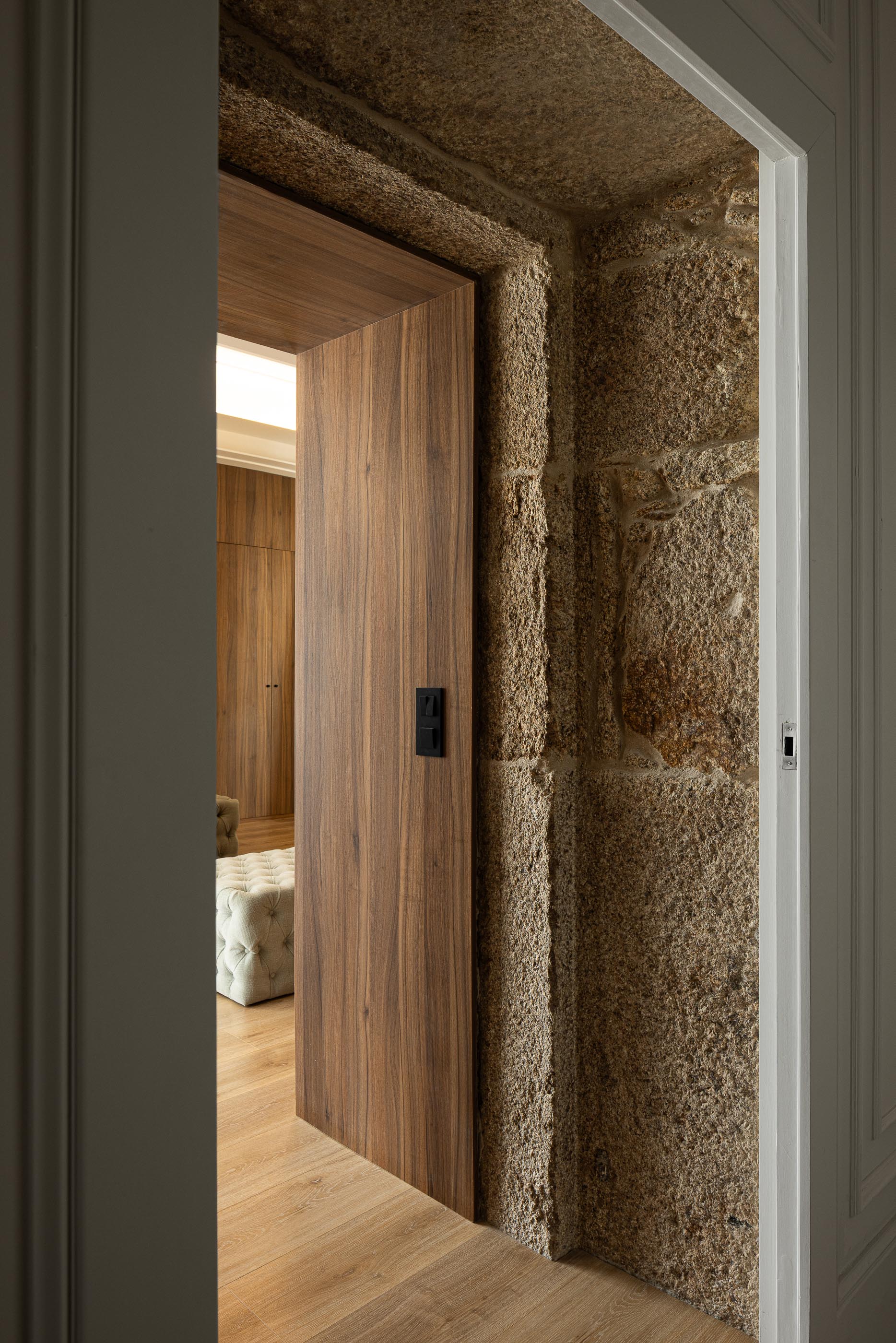 Quarto: Porta em madeira, pavimento em madeira e vislumbre do roupeiro embutido. — Moradia do Retiro arquitetura Ricardo Azevedo Arquitecto em Santo Tirso
