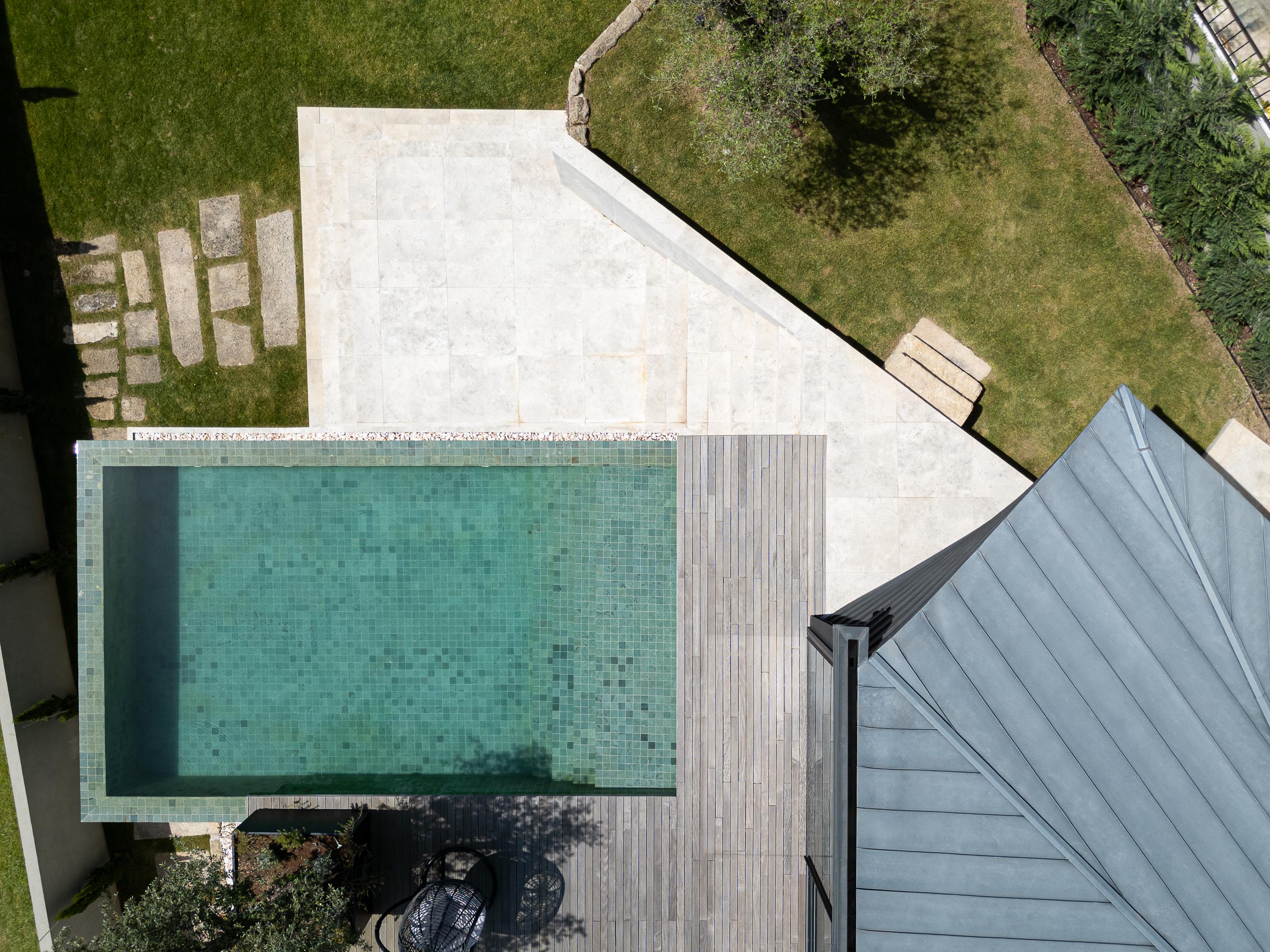 Exterior: Vista aérea da piscina com mosaicos verdes, terraço em madeira e jardim. — Moradia do Retiro arquitetura Ricardo Azevedo Arquitecto em Santo Tirso