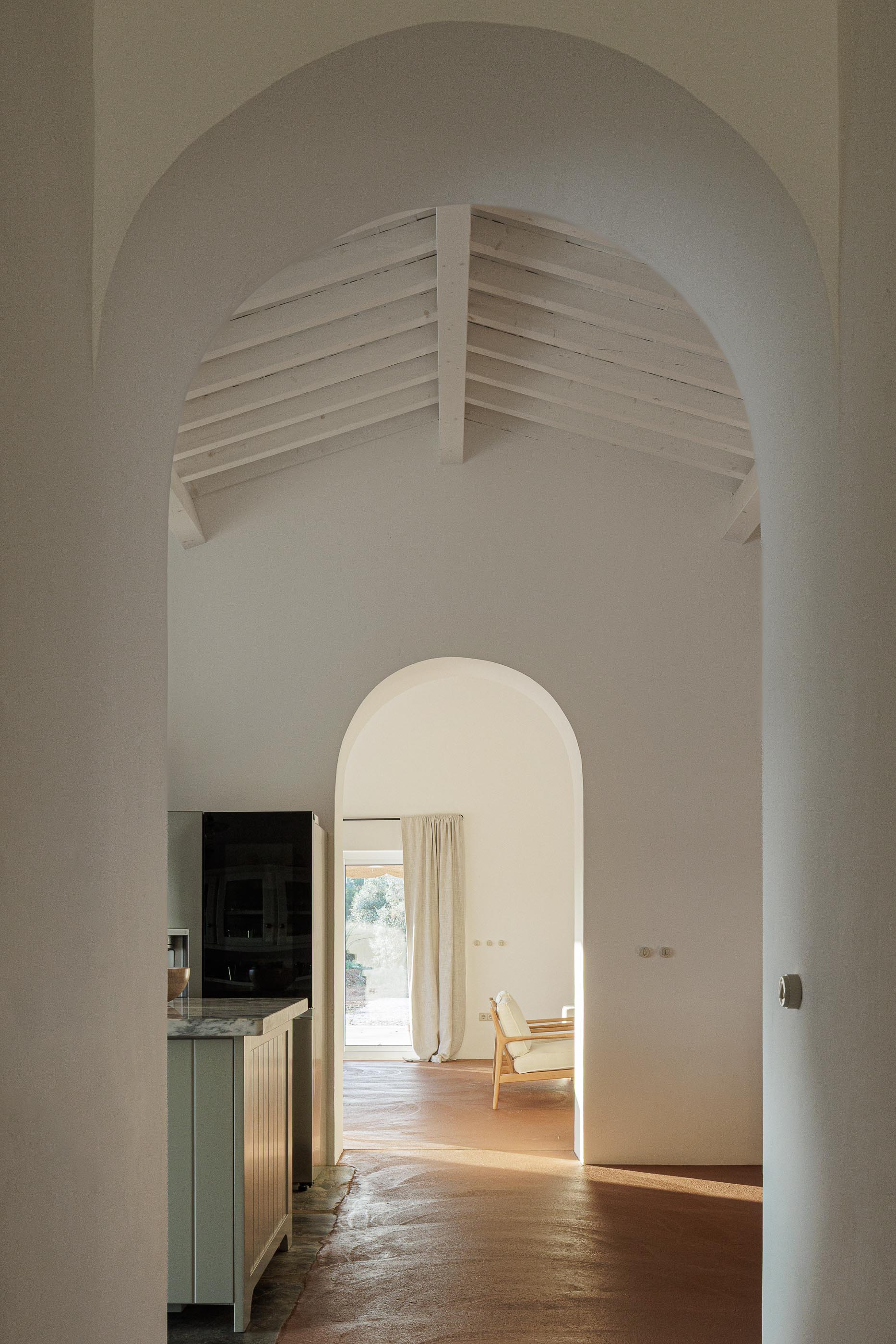 Hall: Vista em perspectiva com arcos, pavimento em tijoleira e teto branco com vigas de madeira. — Monte do Divor arquitetura Vasco Burnay Arquitectura em Estremoz