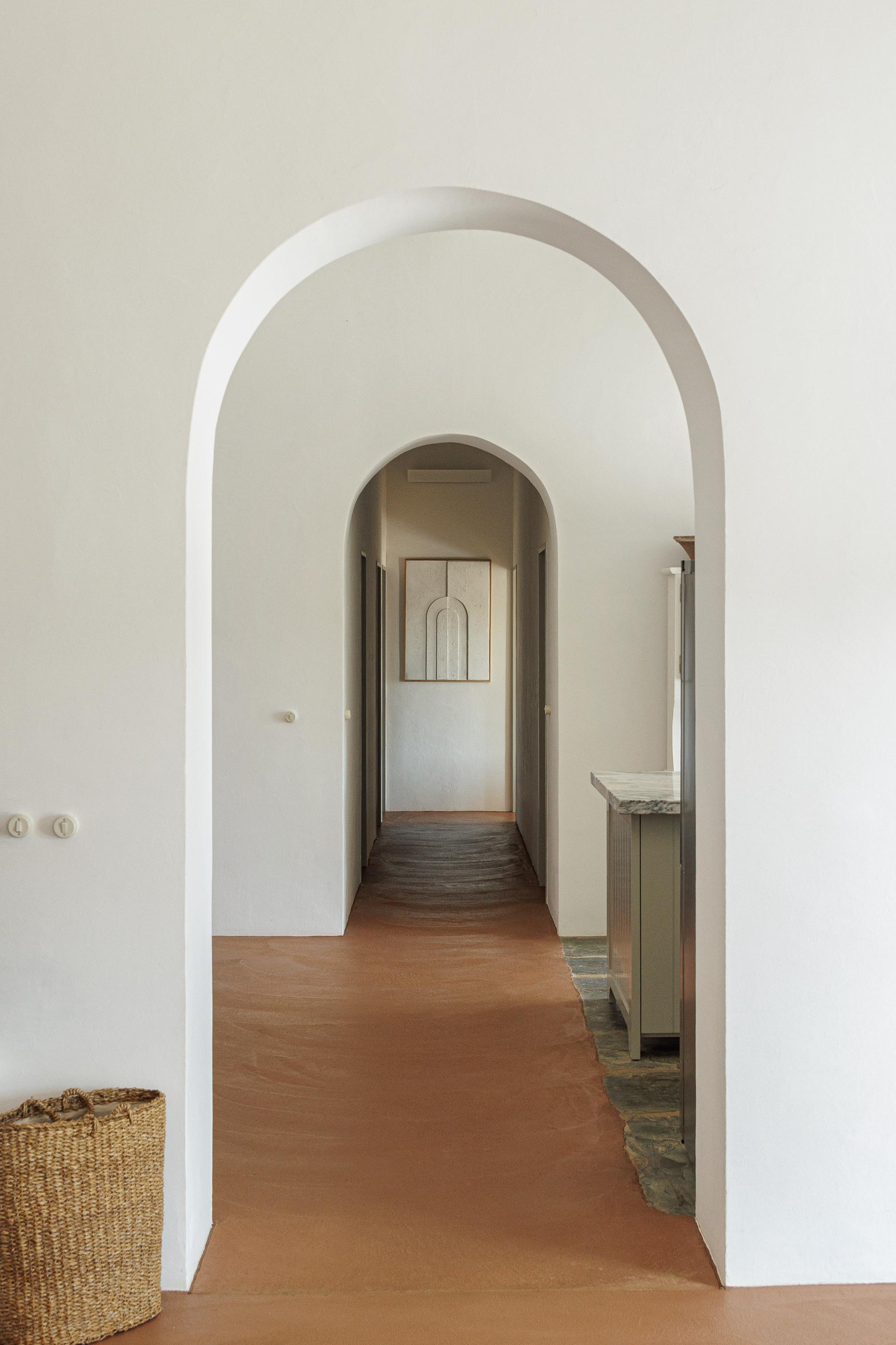 Hall: Vista em perspectiva com arcos, pavimento em tijoleira e teto branco com vigas de madeira. — Monte do Divor arquitetura Vasco Burnay Arquitectura em Estremoz