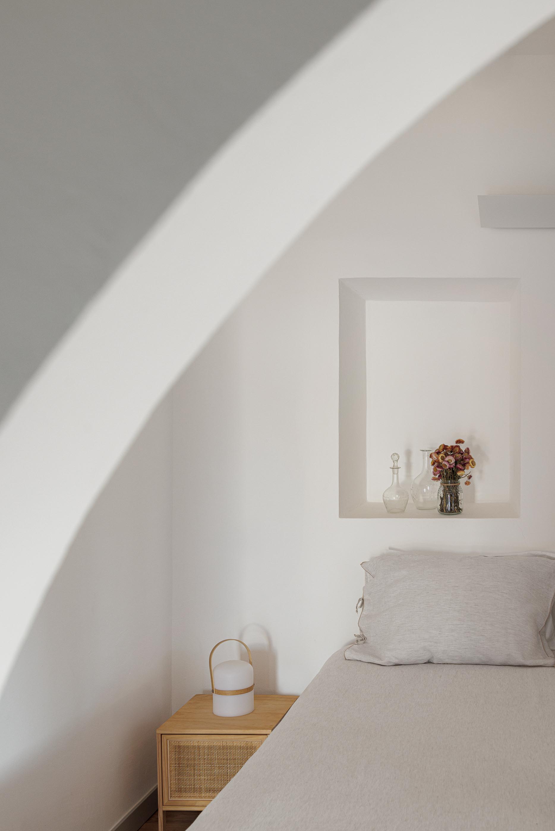 Quarto: Cama de solteiro, mesa de cabeceira em madeira e candeeiro. — Monte do Divor arquitetura Vasco Burnay Arquitectura em Estremoz