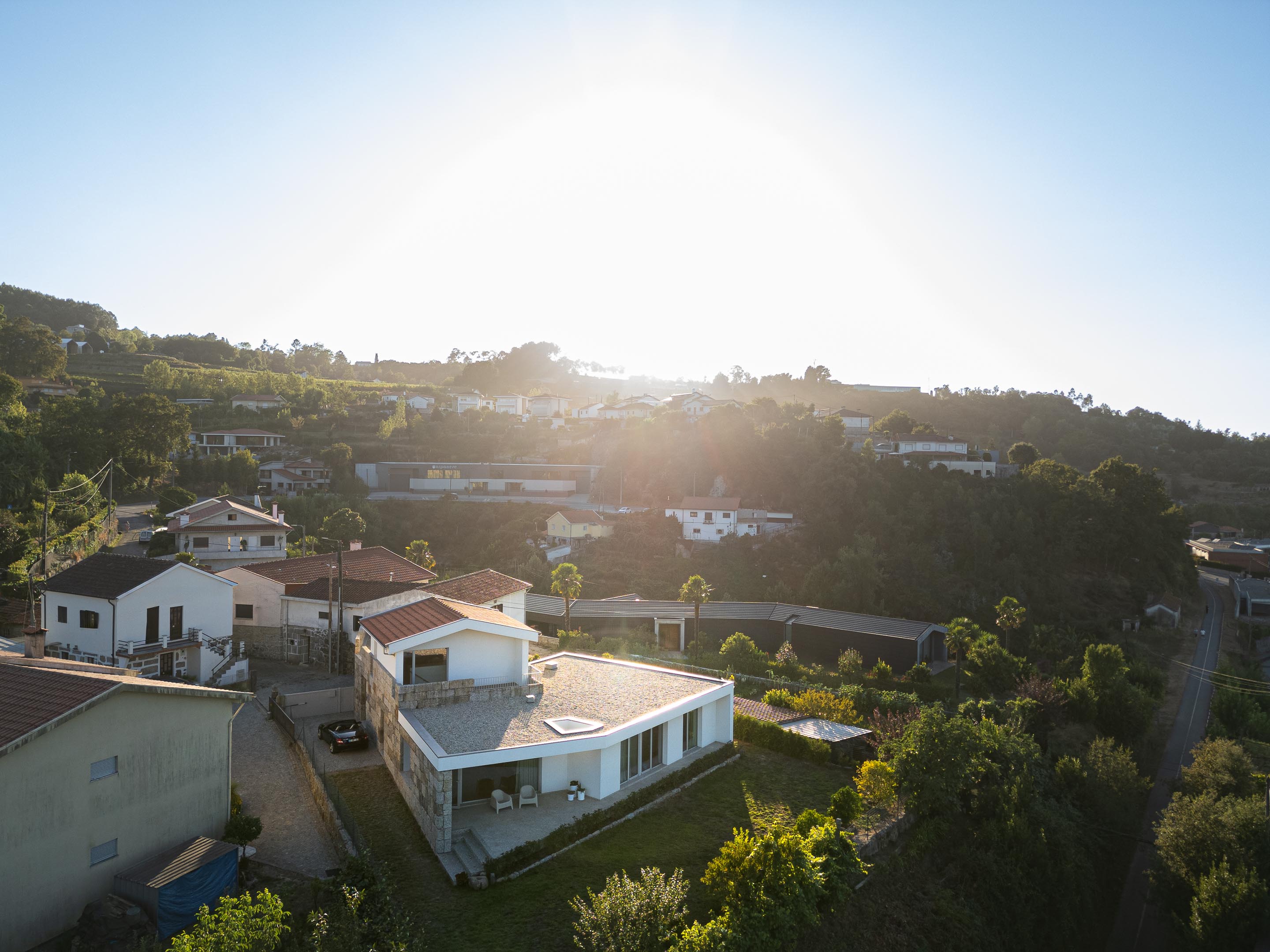 Exterior: Vista aérea da casa e arredores, com telhados de barro e vegetação exuberante. — Casa em Mesão Frio arquitetura felixARQS – Daniel Félix Arquitectos em Guimarães