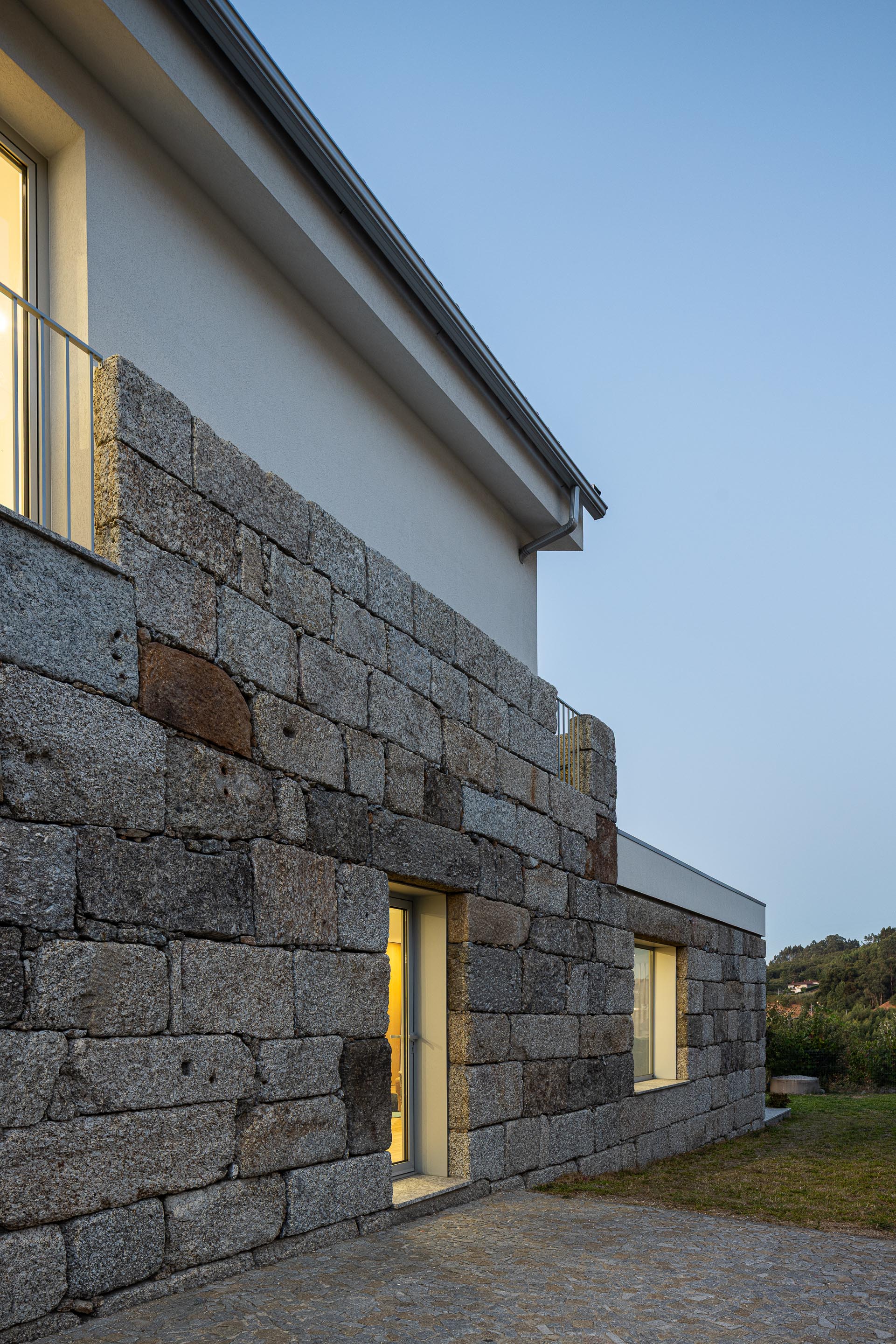 Alpendre: Alpendre iluminado com cadeiras brancas, cortinas e vista para o céu estrelado. — Casa em Mesão Frio arquitetura felixARQS – Daniel Félix Arquitectos em Guimarães