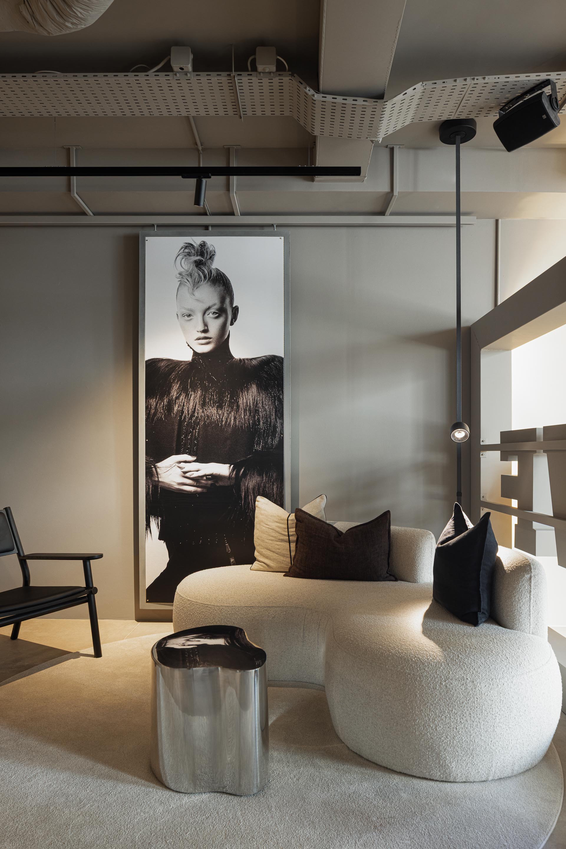 Zona de Espera: Sofá curvo em bouclé, mesa lateral metálica, alcatifa clara e iluminação minimalista. — Vasco Freitas Salon arquitetura MAT Arquitetura e Interiores em Porto