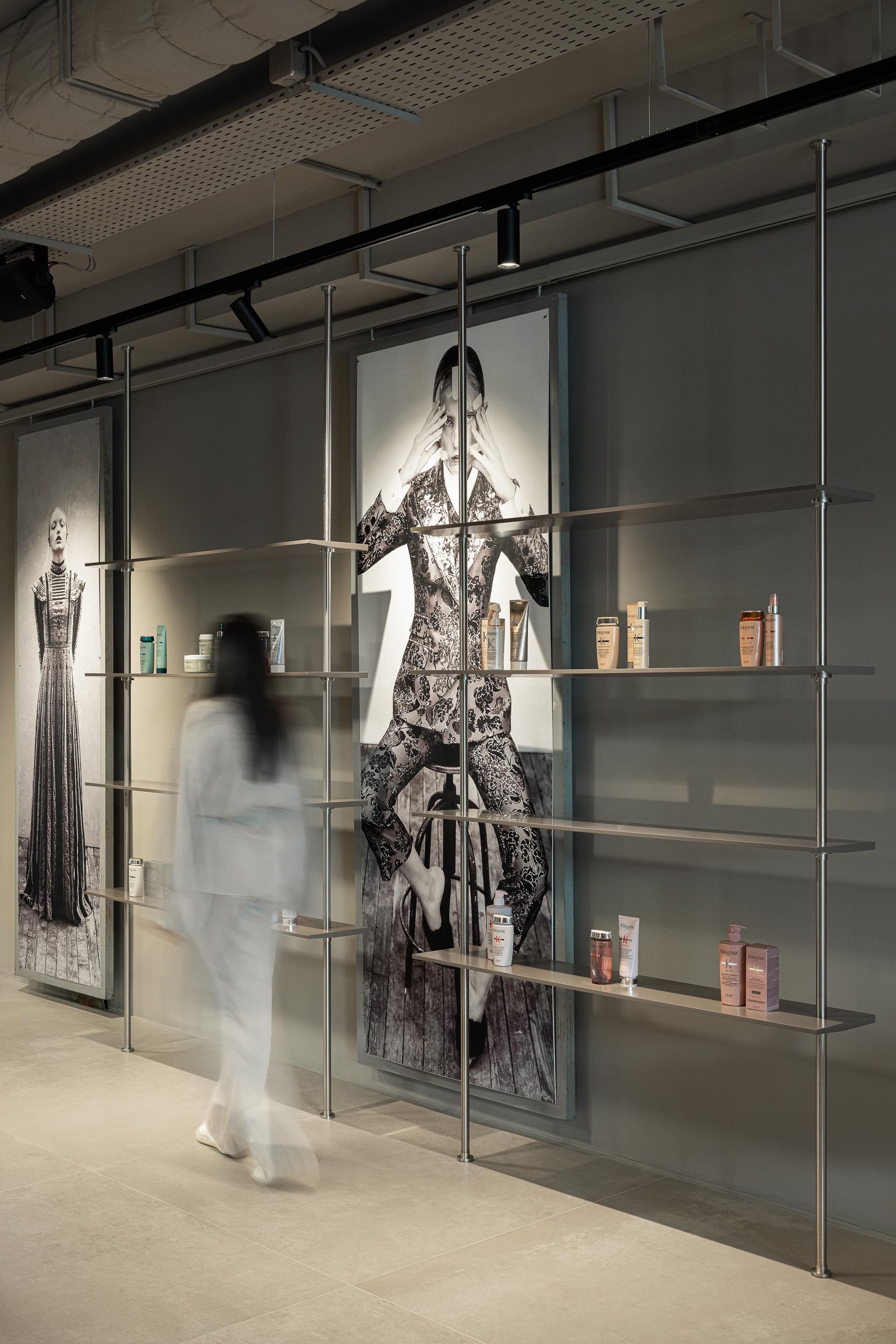 Salão: Prateleiras metálicas com produtos de cabelo, imagens de moda e pavimento cerâmico em tons neutros. — Vasco Freitas Salon arquitetura MAT Arquitetura e Interiores em Porto