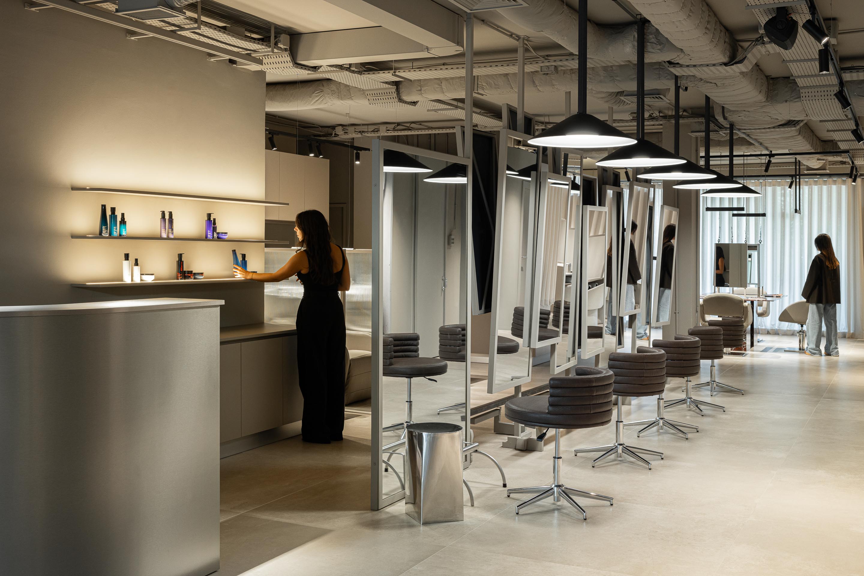 Salão: Espaços de trabalho com espelhos, cadeiras giratórias e prateleiras iluminadas com produtos. — Vasco Freitas Salon arquitetura MAT Arquitetura e Interiores em Porto