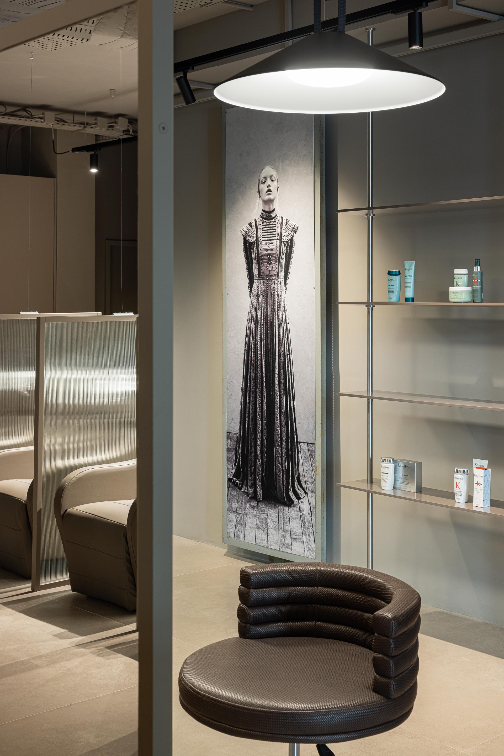 Salão: Cadeira de cabeleireiro, prateleiras com produtos e imagem de moda. — Vasco Freitas Salon arquitetura MAT Arquitetura e Interiores em Porto
