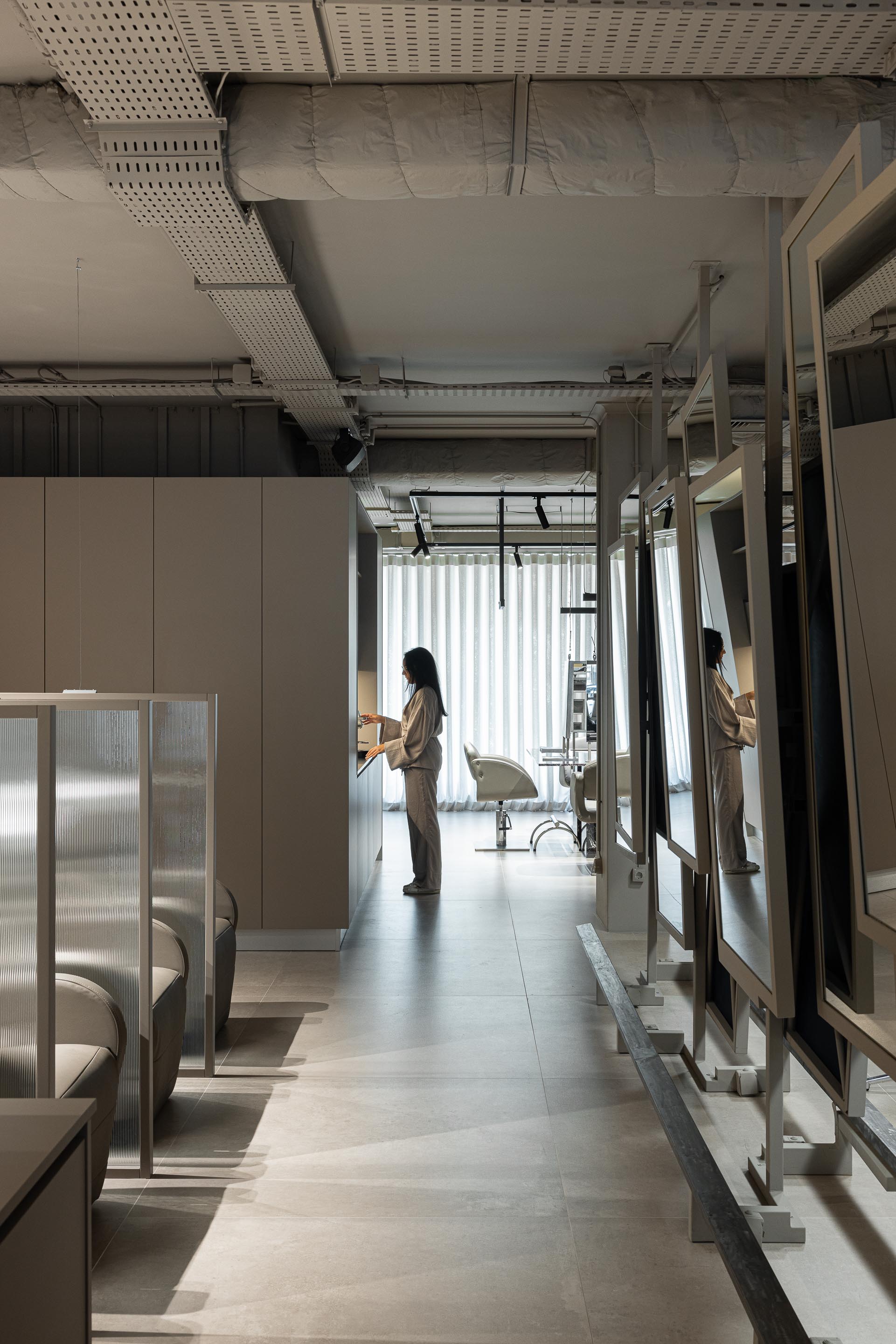 Salão: Corredor com espaços de trabalho, divisórias em vidro canelado e cadeiras de espera. — Vasco Freitas Salon arquitetura MAT Arquitetura e Interiores em Porto