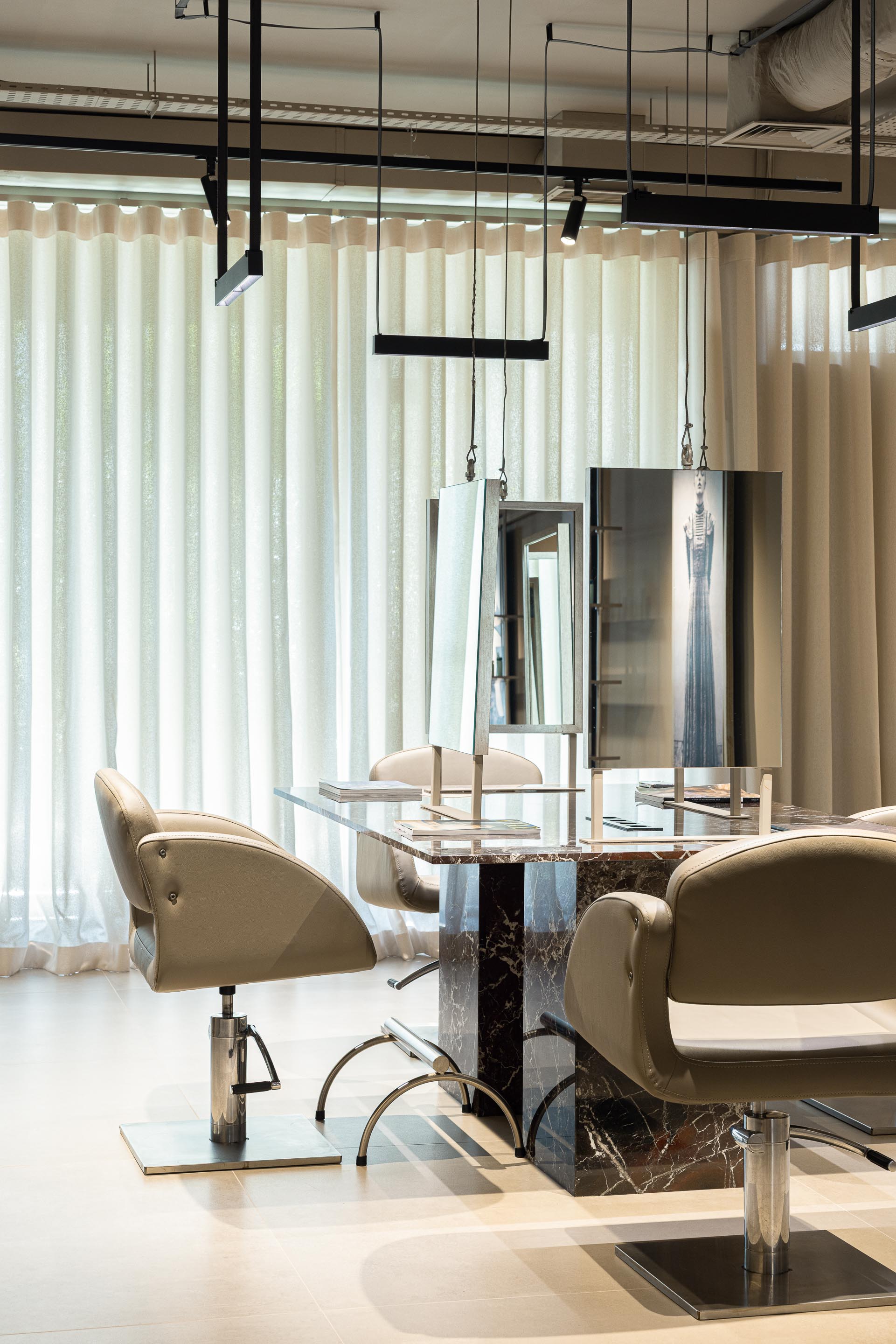 Salão: Espaços de trabalho com espelhos, cadeiras giratórias e cortinas claras. — Vasco Freitas Salon arquitetura MAT Arquitetura e Interiores em Porto
