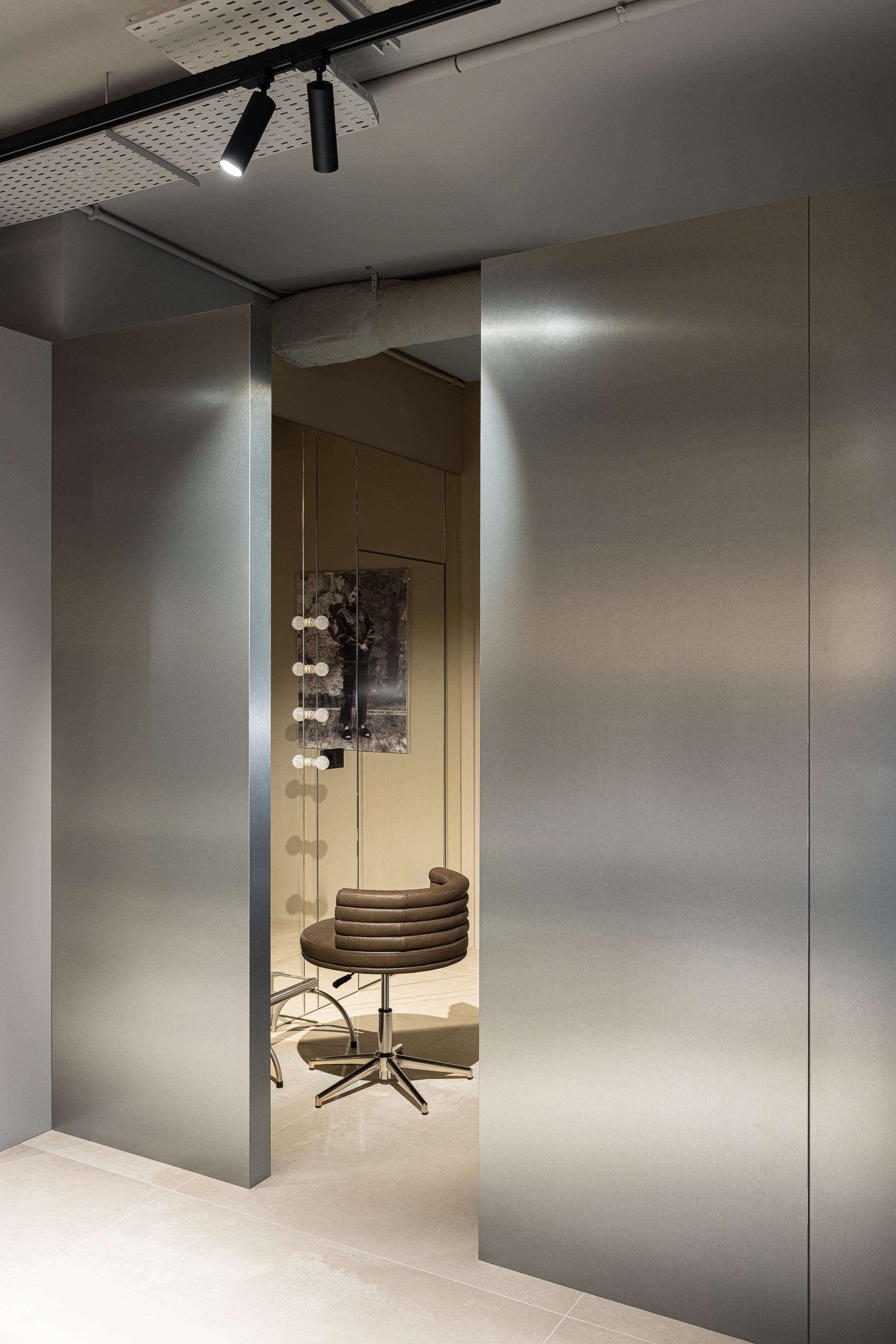 Salão: Espelhos que refletem a zona de espera e espaços de trabalho. — Vasco Freitas Salon arquitetura MAT Arquitetura e Interiores em Porto