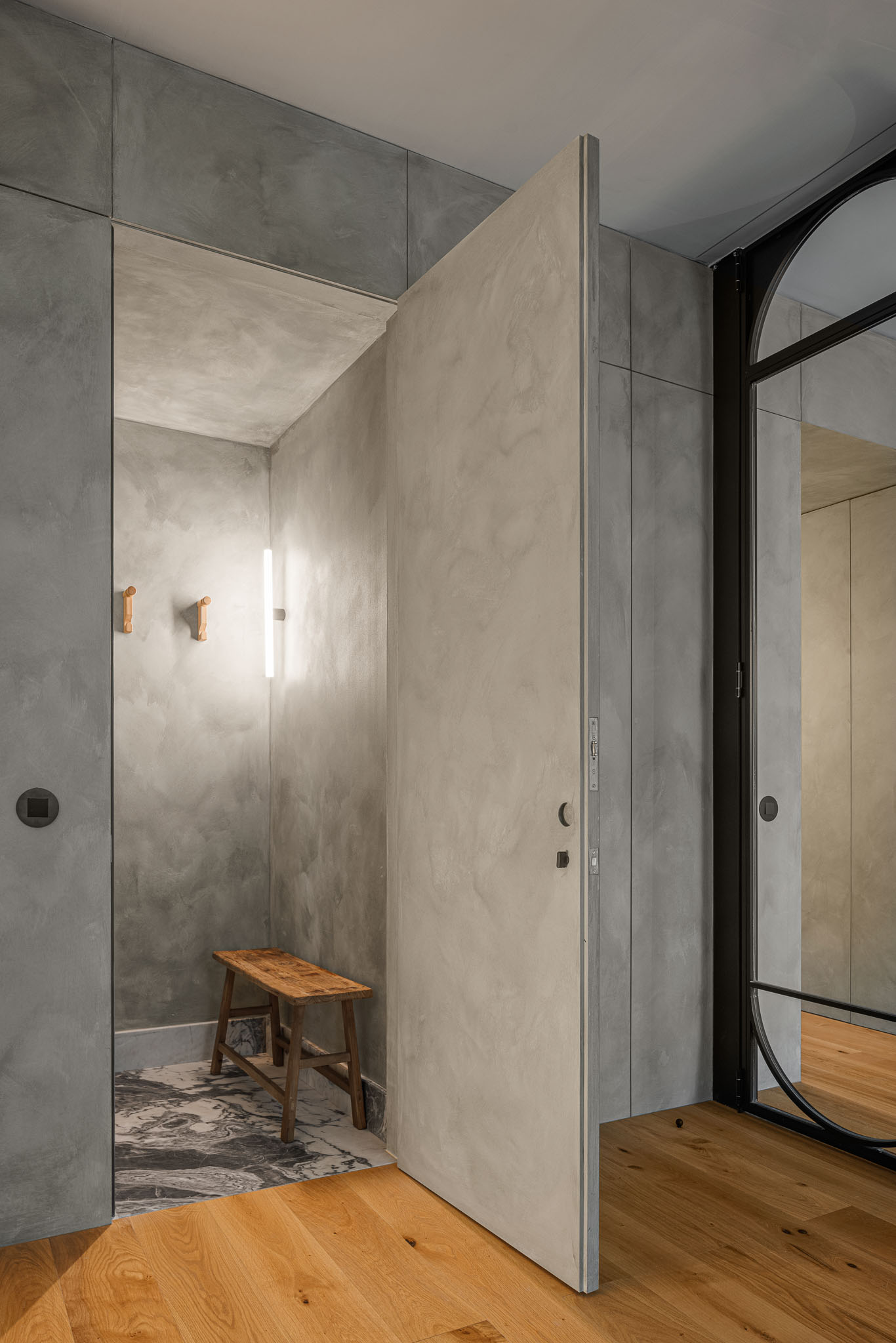 Quarto: Detalhe da porta de vidro e ferro preto, parede em cimento afagado e cortina de linho. — Urban Retreat arquitetura Atelier Réalité em Lisboa