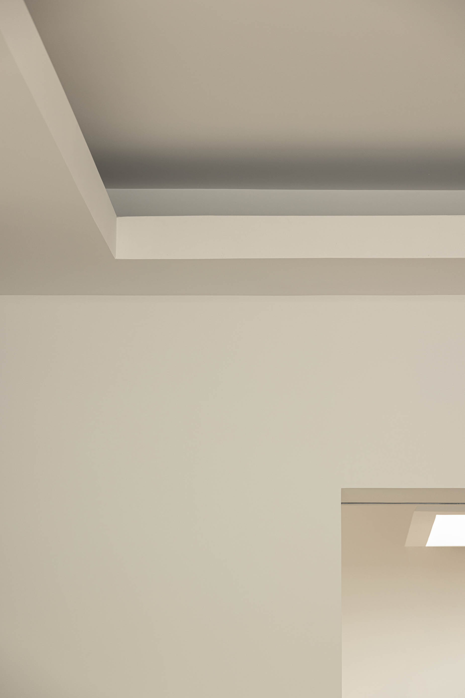 Detalhe do teto branco com iluminação indireta e acesso a outra divisão. — Reconversão do Talho Central arquitetura José Pedro Lima Arquiteto em Coimbra