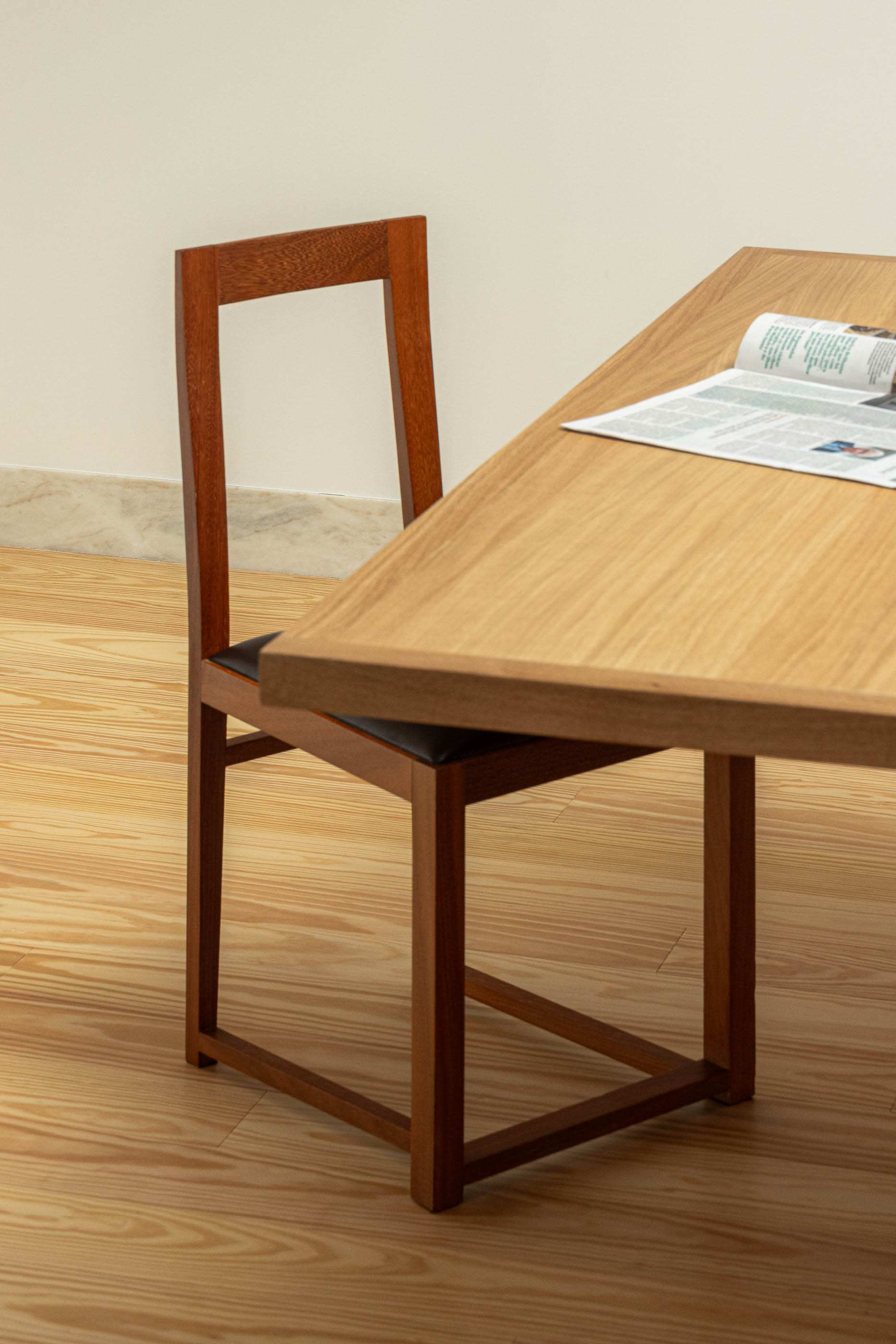 Detalhe da mesa de madeira e cadeira na sala de reuniões. — Reconversão do Talho Central arquitetura José Pedro Lima Arquiteto em Coimbra