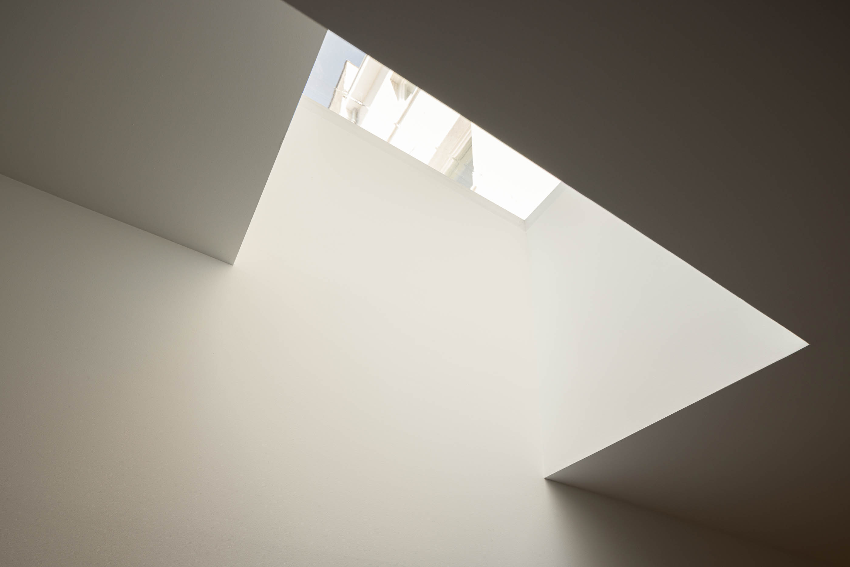 Detalhe do teto branco com iluminação zenital. — Reconversão do Talho Central arquitetura José Pedro Lima Arquiteto em Coimbra