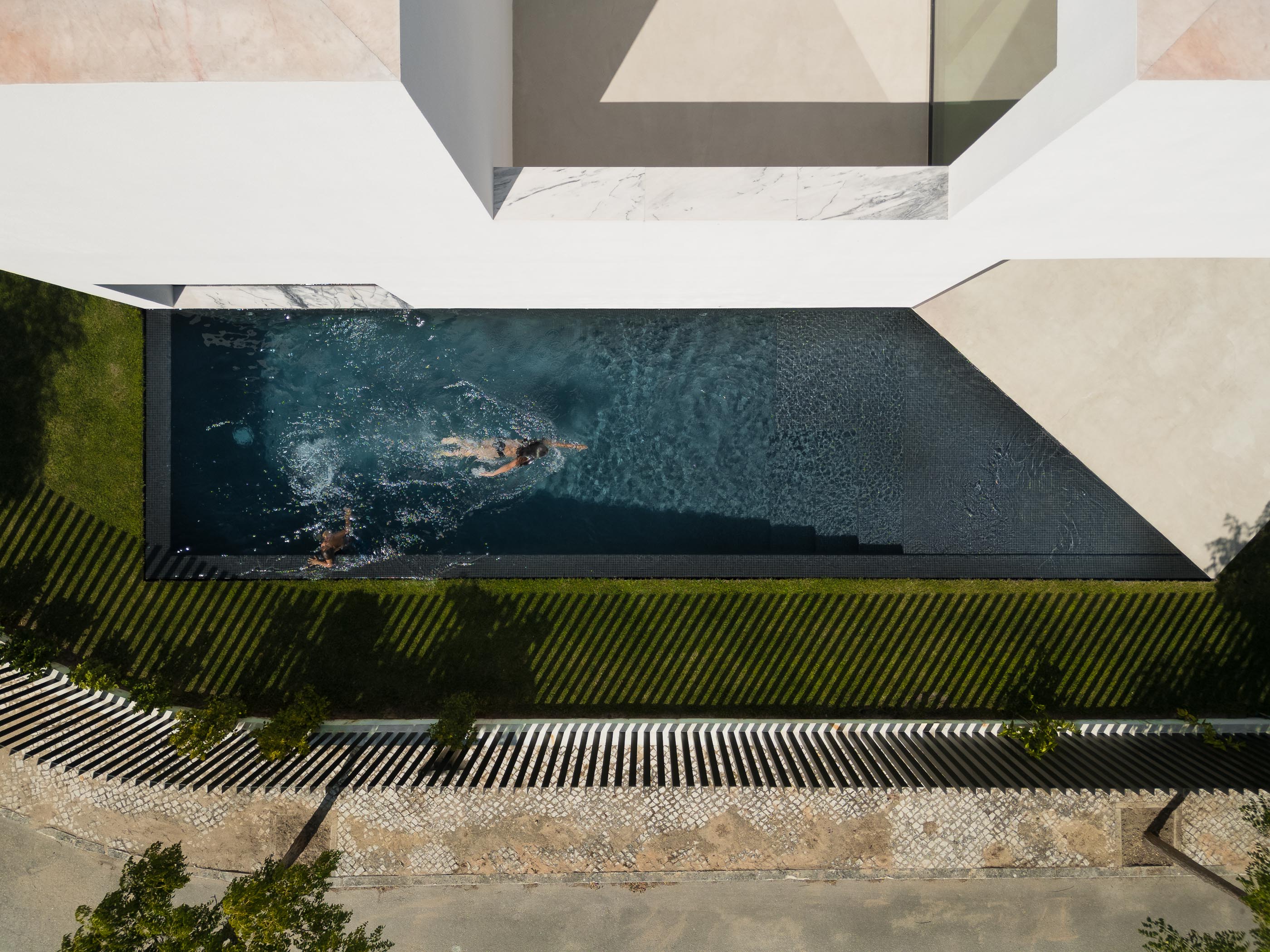 Hall de entrada: Escadas brancas flutuantes, porta preta e pavimento cinza. — Casa DR arquitetura NMDARQ – Nuno Miguel Dias, Arquitecto em Torres Novas