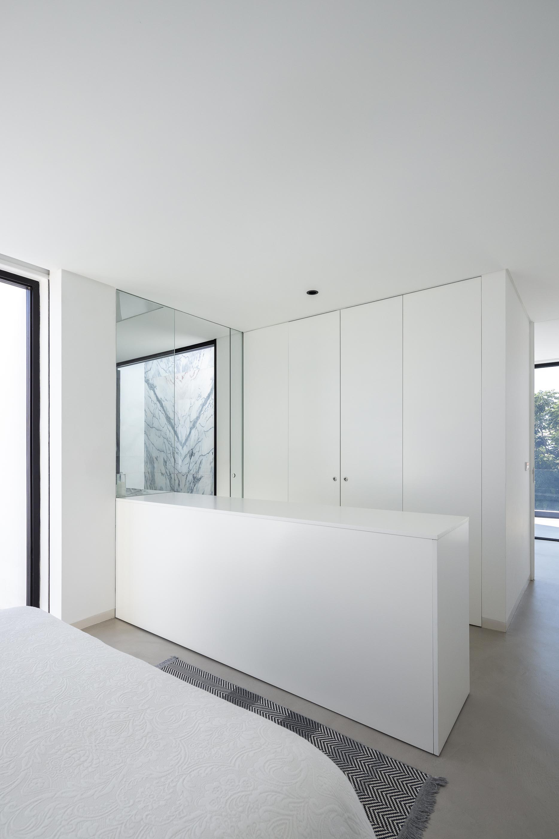 Cozinha: Claraboia, ilha em mármore, candeeiro preto e vista para o exterior. — Casa DR arquitetura NMDARQ – Nuno Miguel Dias, Arquitecto em Torres Novas