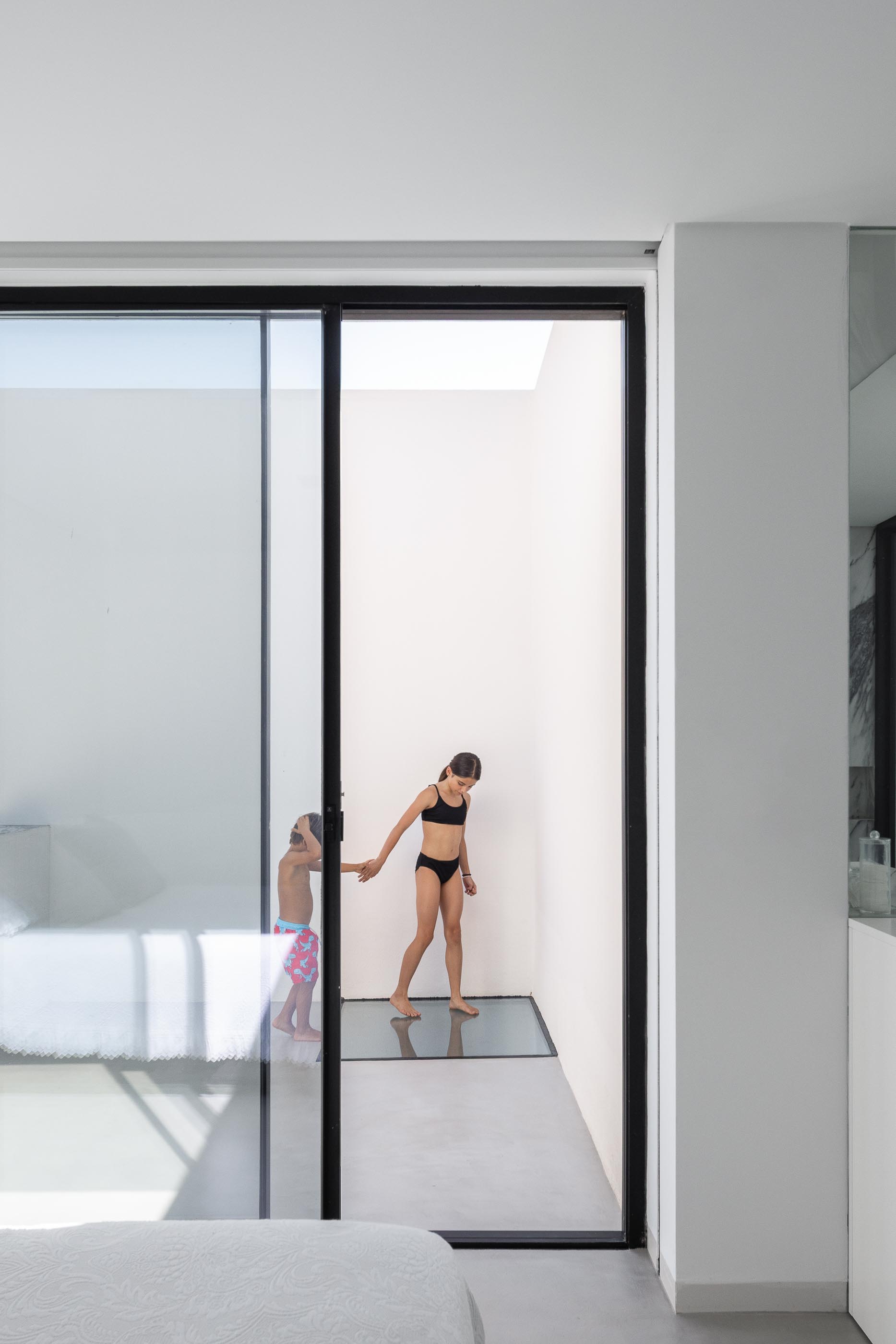 Cozinha: Ilha em mármore com bancos pretos, mesa de madeira e candeeiro preto. — Casa DR arquitetura NMDARQ – Nuno Miguel Dias, Arquitecto em Torres Novas