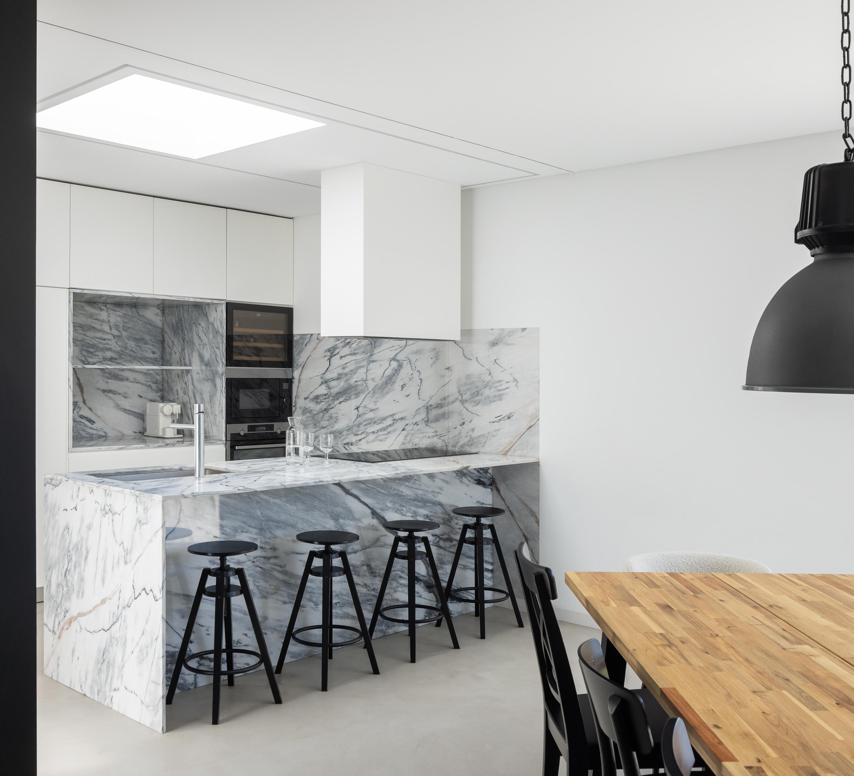 Cozinha: Ilha em mármore com lava-loiça e claraboia ao teto. — Casa DR arquitetura NMDARQ – Nuno Miguel Dias, Arquitecto em Torres Novas