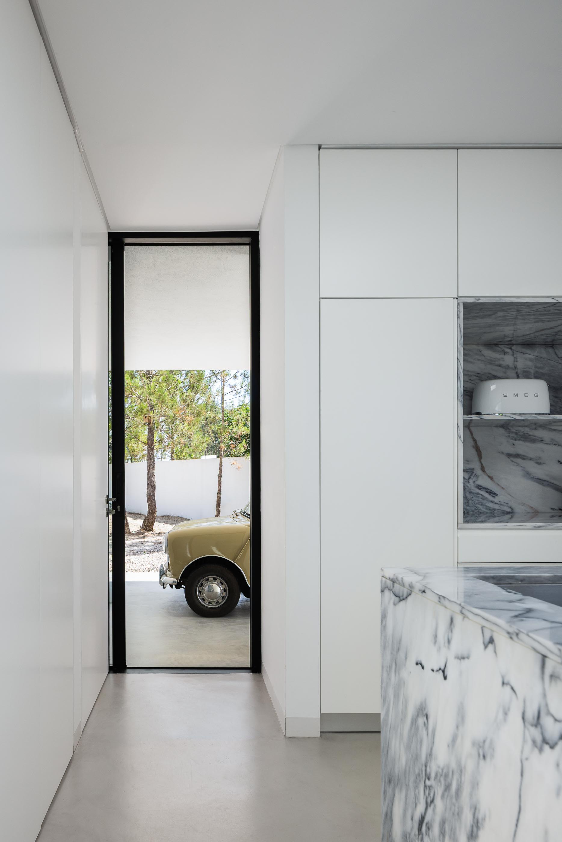 Exterior: Carro clássico bege estacionado na garagem da casa branca minimalista. — Casa DR arquitetura NMDARQ – Nuno Miguel Dias, Arquitecto em Torres Novas