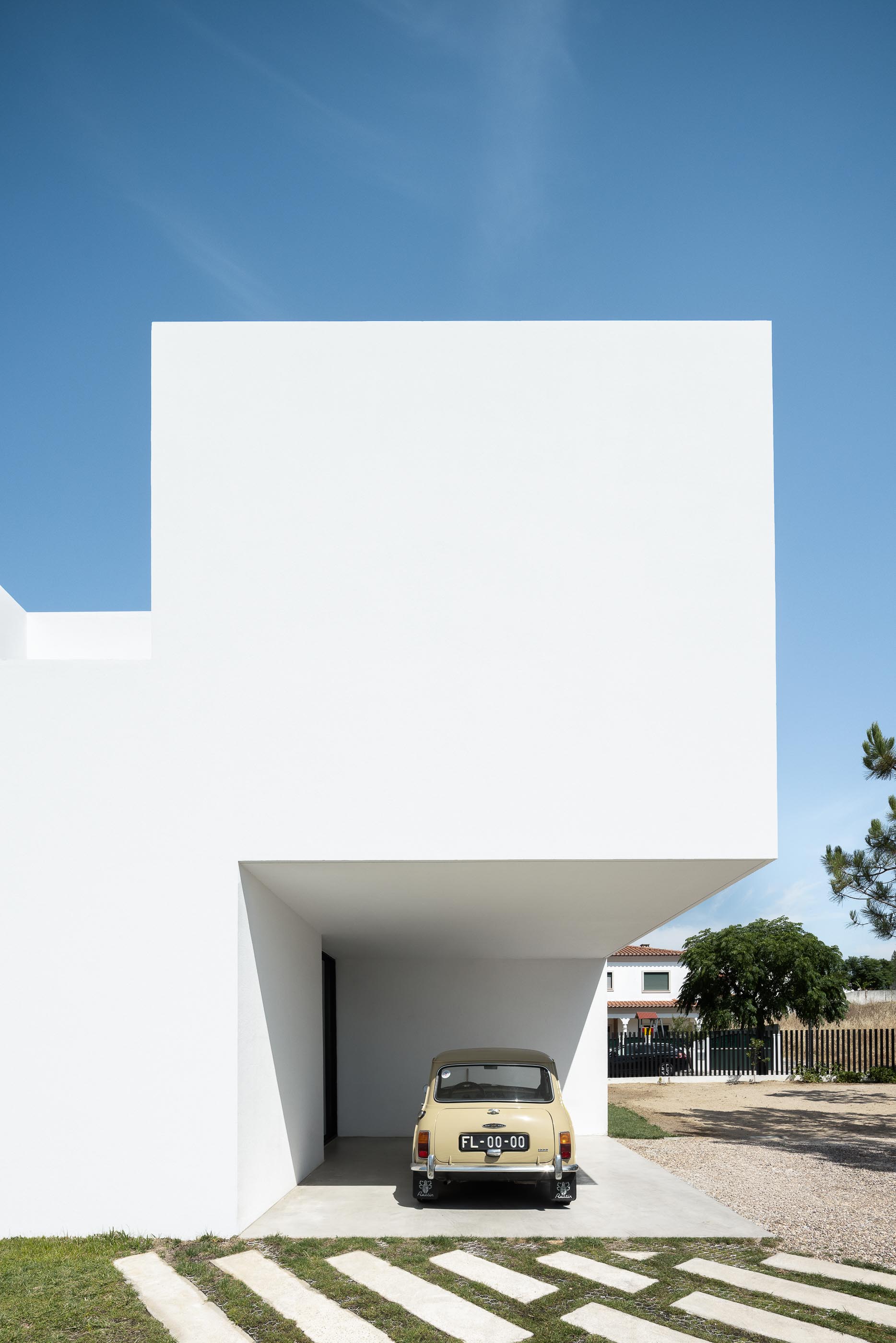 Exterior: Vista aérea da casa branca minimalista com piscina e garagem. — Casa DR arquitetura NMDARQ – Nuno Miguel Dias, Arquitecto em Torres Novas